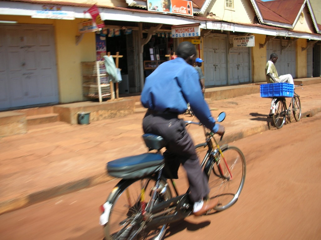 A bodaboda bicycle taxi driver in Kampala, Uganda, baile atha cliath via Wikimedia Commons