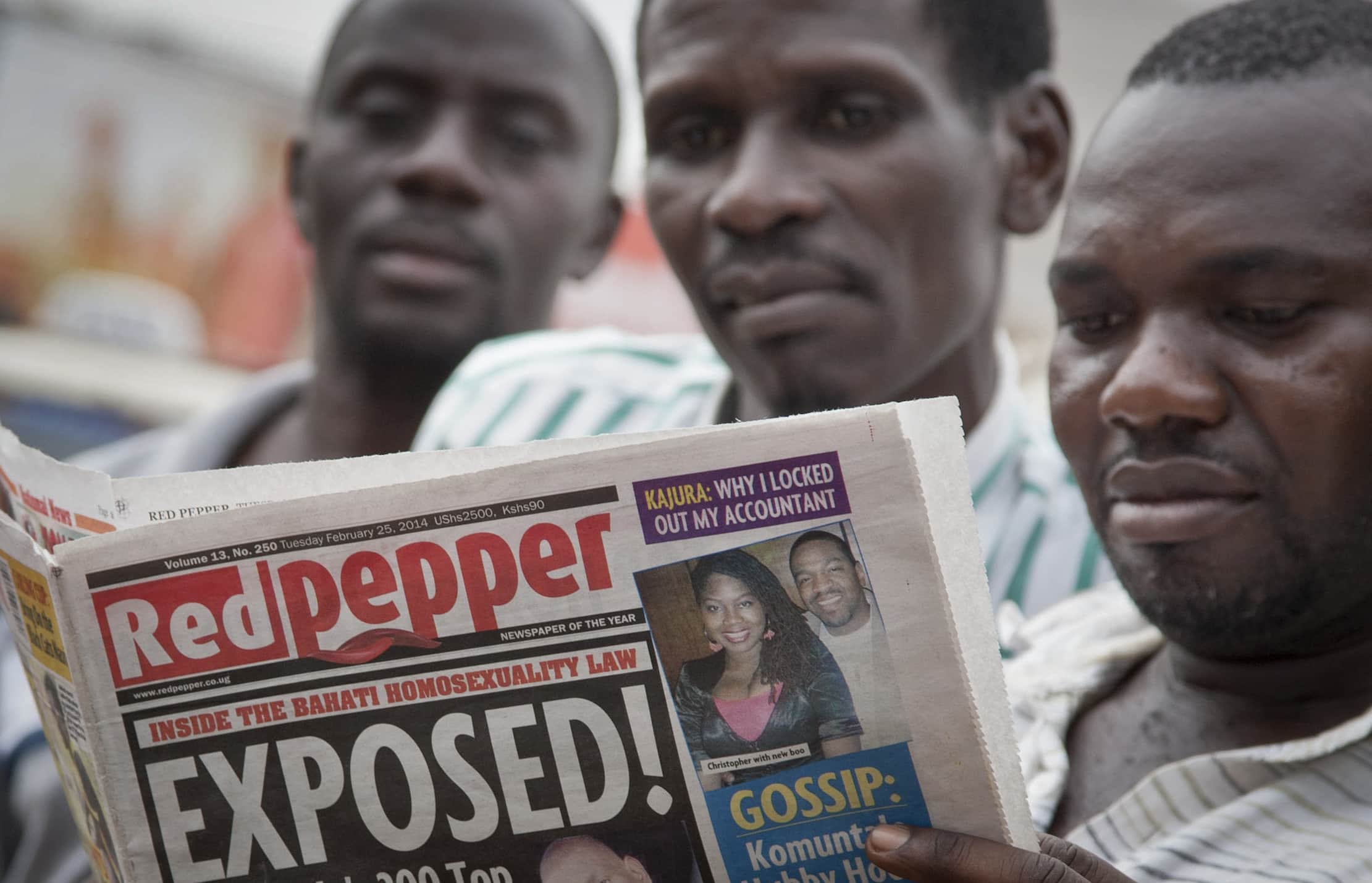 A Ugandan reads a copy of the "Red Pepper" tabloid newspaper in Kampala, 25 February 2014., AP Photo/Rebecca Vassie