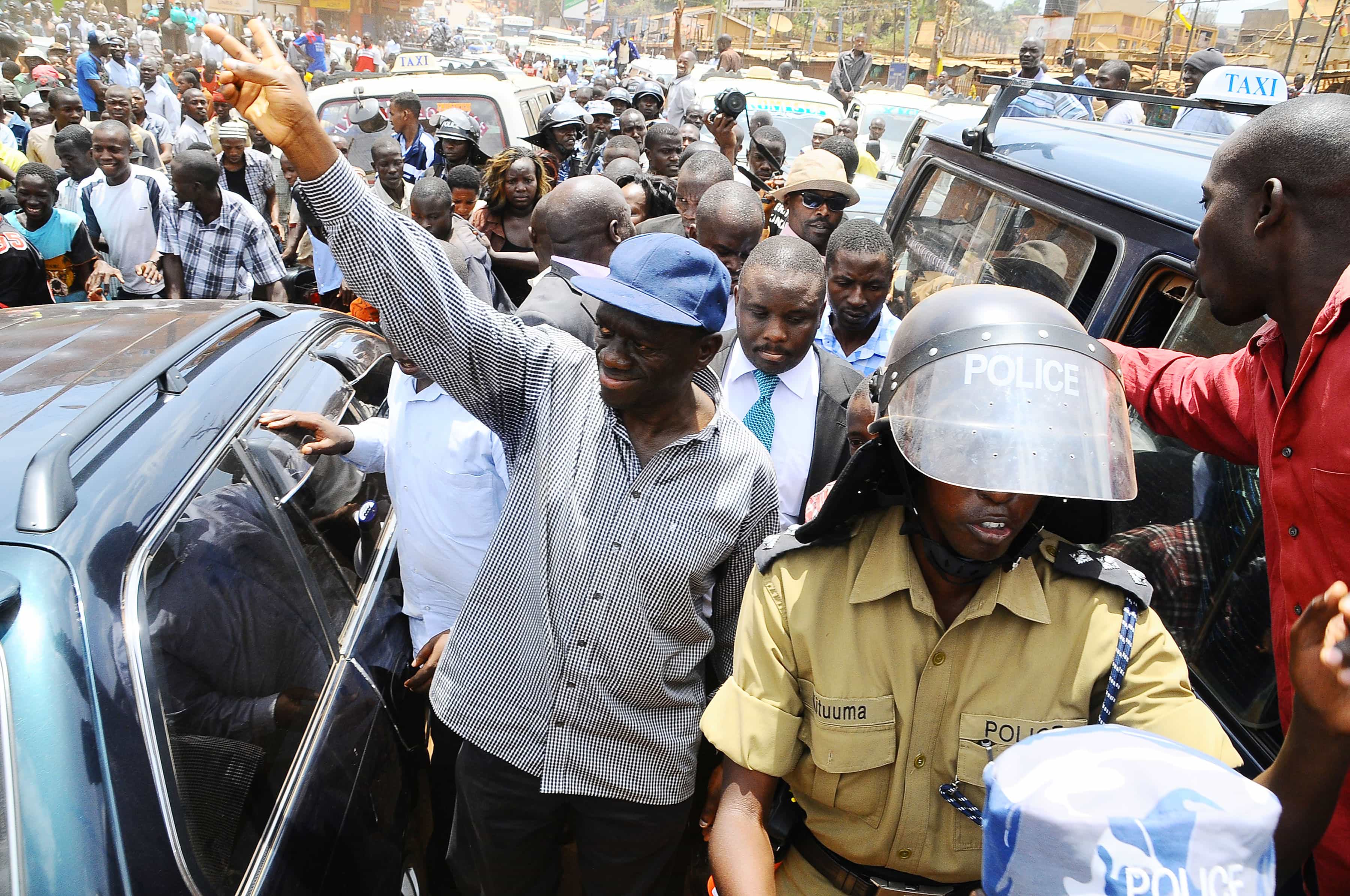 Forum for Democratic Change opposition leader Kizza Besigye, left, gestures the party sign before being arrested for holding a rally in Kampala, 21 March 2012., AP Photo/Stephen Wander