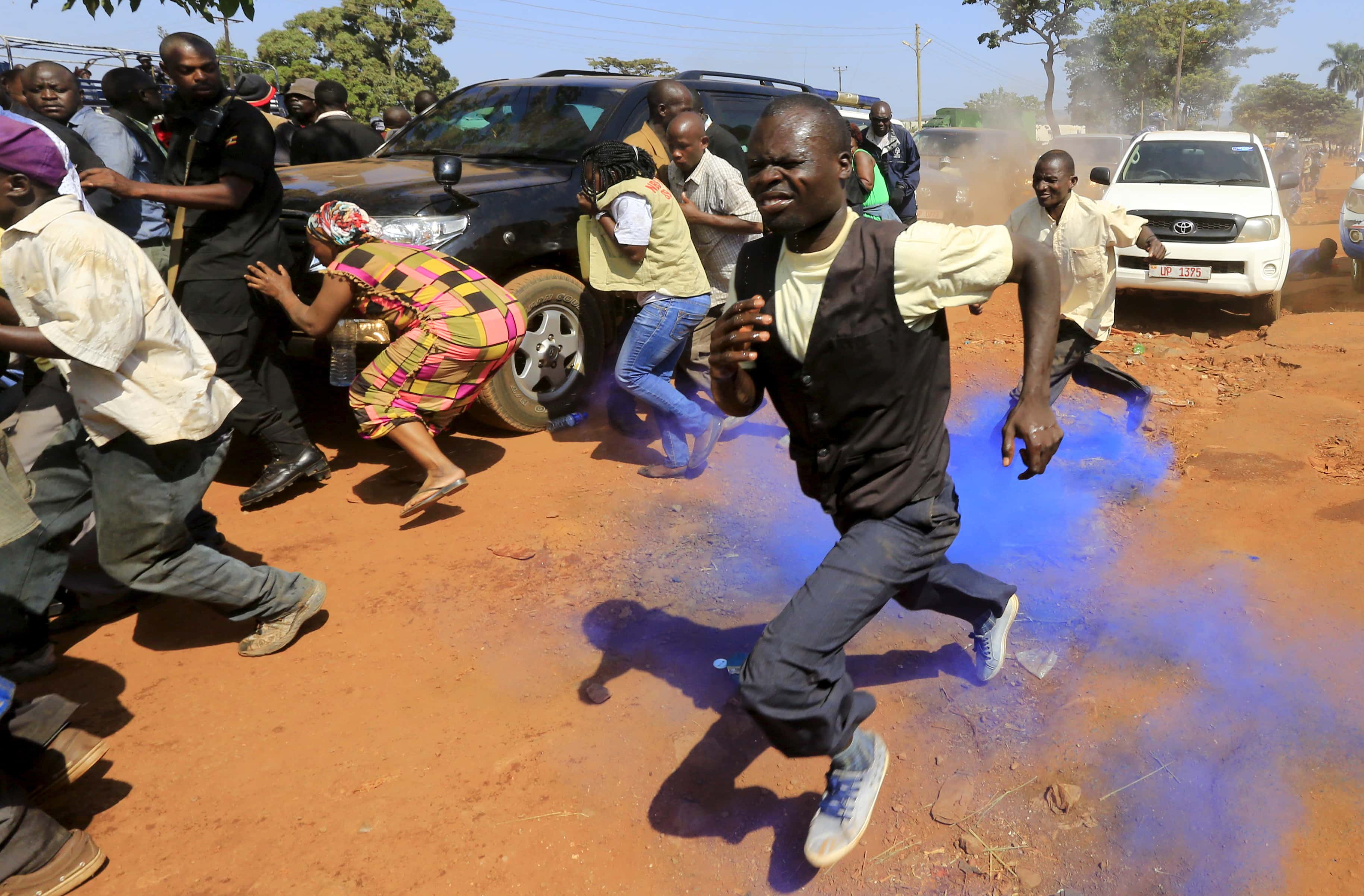 Supporters of Uganda's former Prime Minister Amama Mbabazi run from coloured tear gas canister police used to disperse a gathering in Jinja town in eastern Uganda, 10 September 2015, REUTERS/James Akena