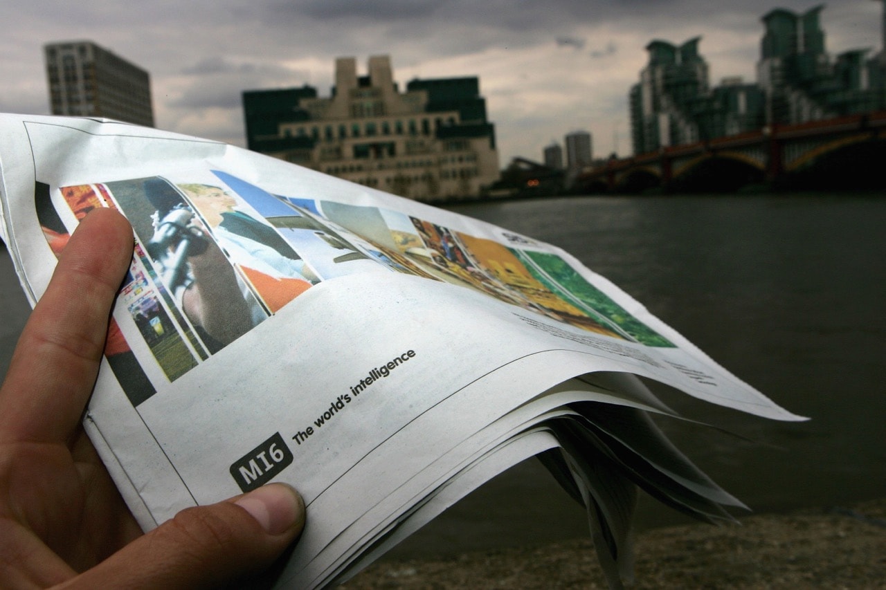 A newspaper with an advertisement seeking new MI6 employees is shown with the MI6 headquarters in the background, in London, England, 27 April 2006, Daniel Berehulak/Getty Images