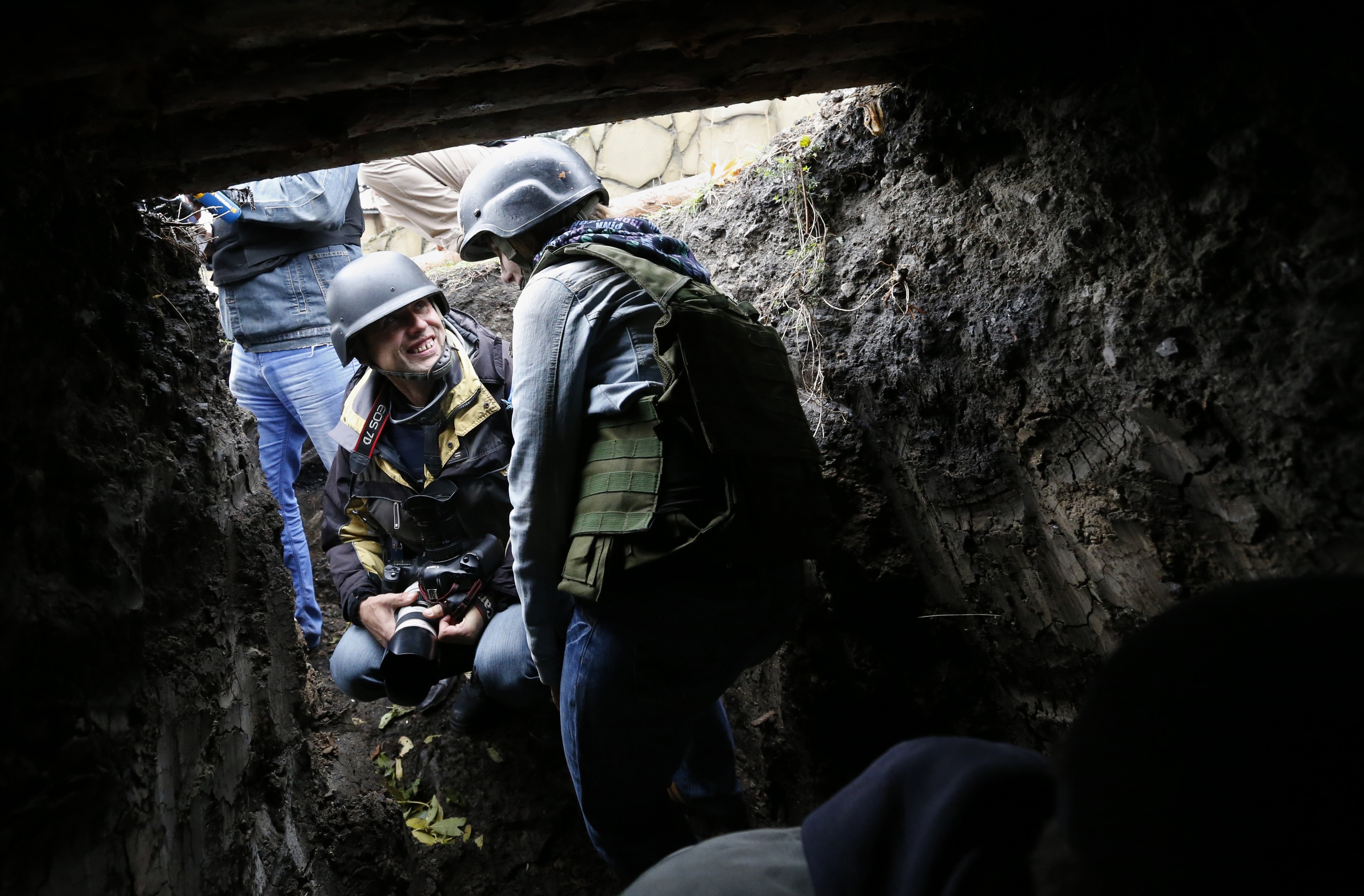 Journalists take cover during a shelling alert at the checkpoint near Debaltseve, eastern Ukraine, 25 September 2014, REUTERS/David Mdzinarishvili