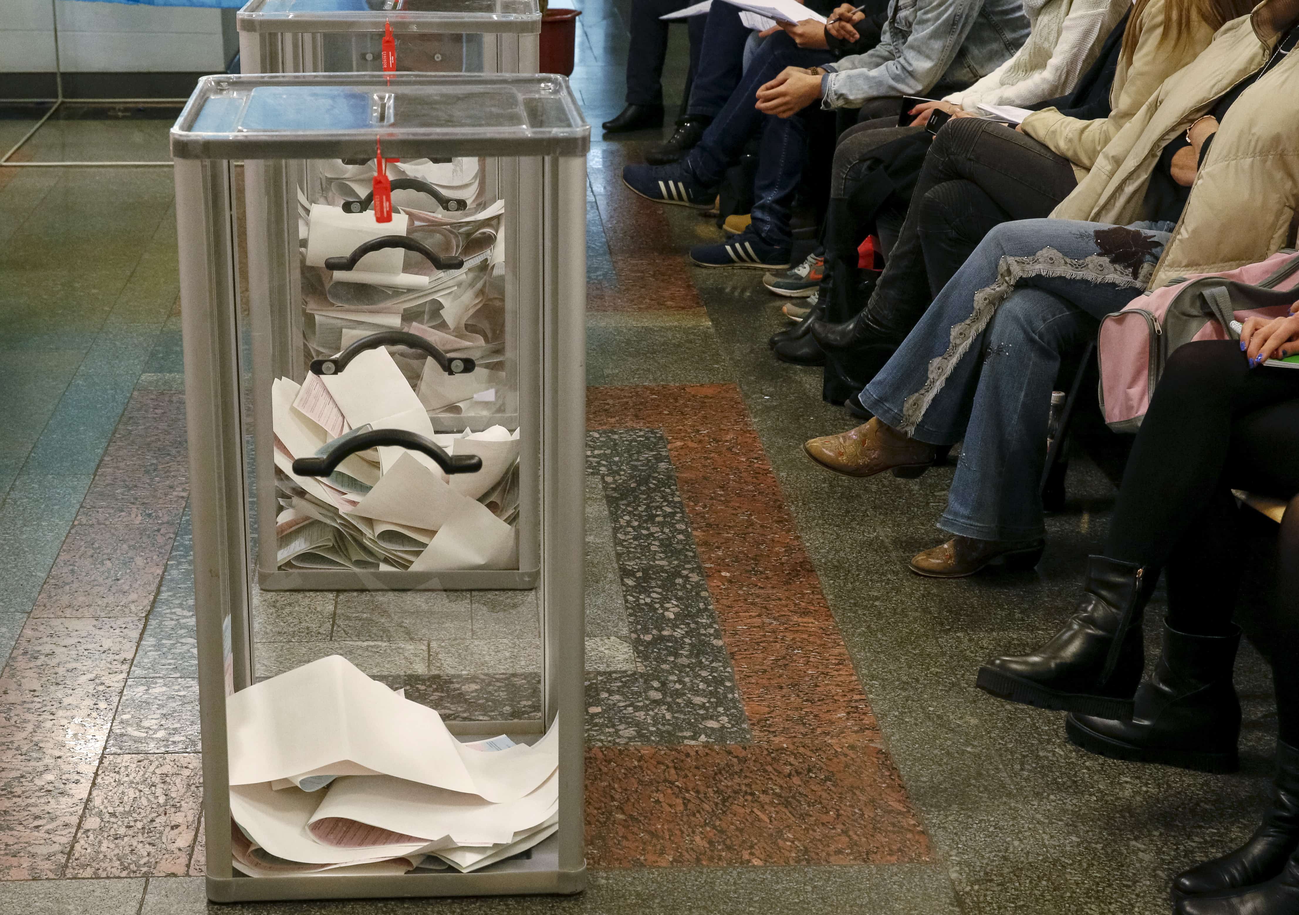 Observers wait for the start of ballot counting at a polling station after voting day in Kiev, 25 October 2015, REUTERS/Gleb Garanich