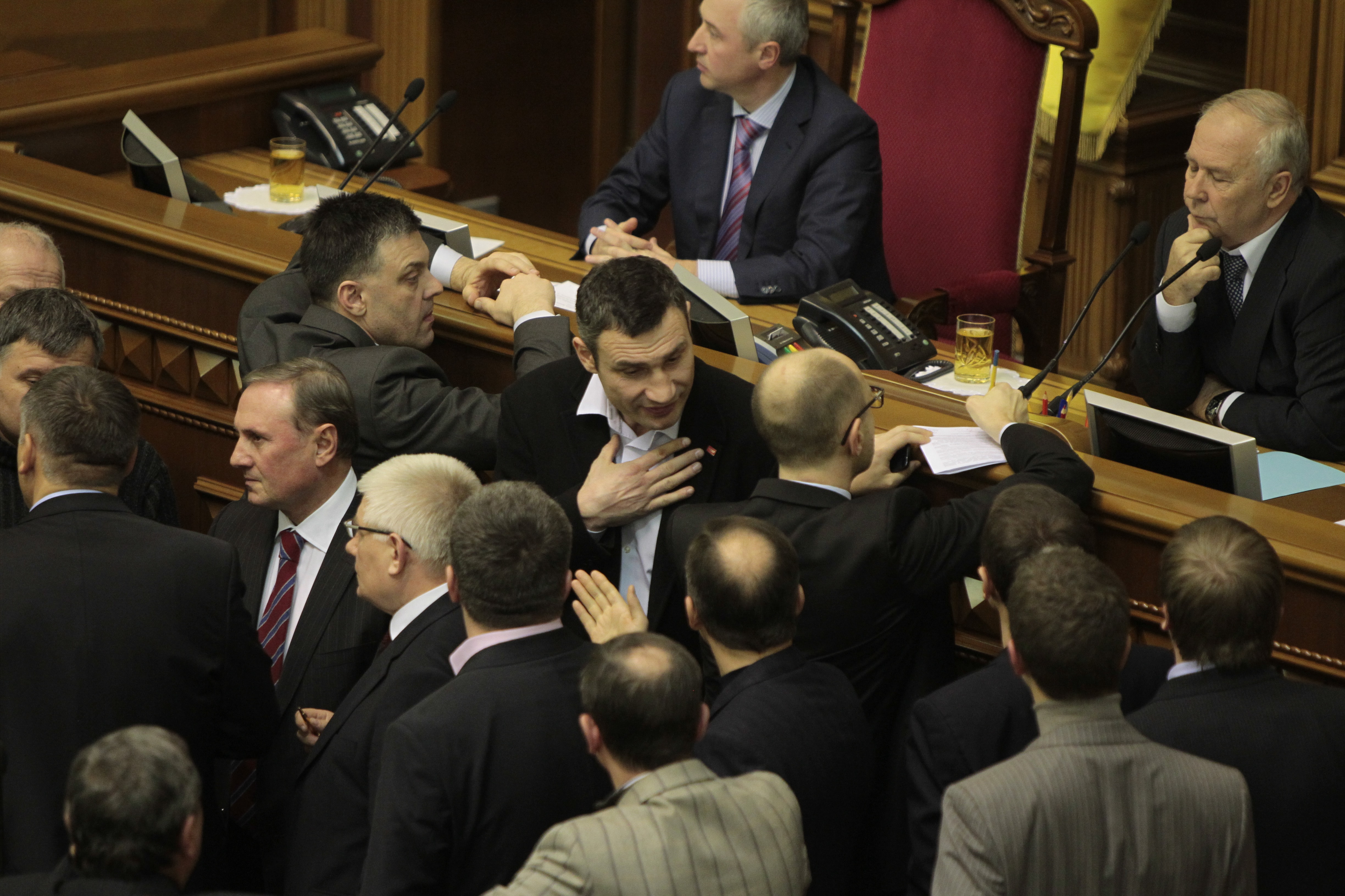 Ukrainian opposition leaders Oleh Tyahnybok, centre left, Vitali Klitschko, centre, and Arseniy Yatsenyuk talk to lawmakers in the parliament session hall in Kiev, 29 January 2014., AP Photo/Sergei Chuzavkov