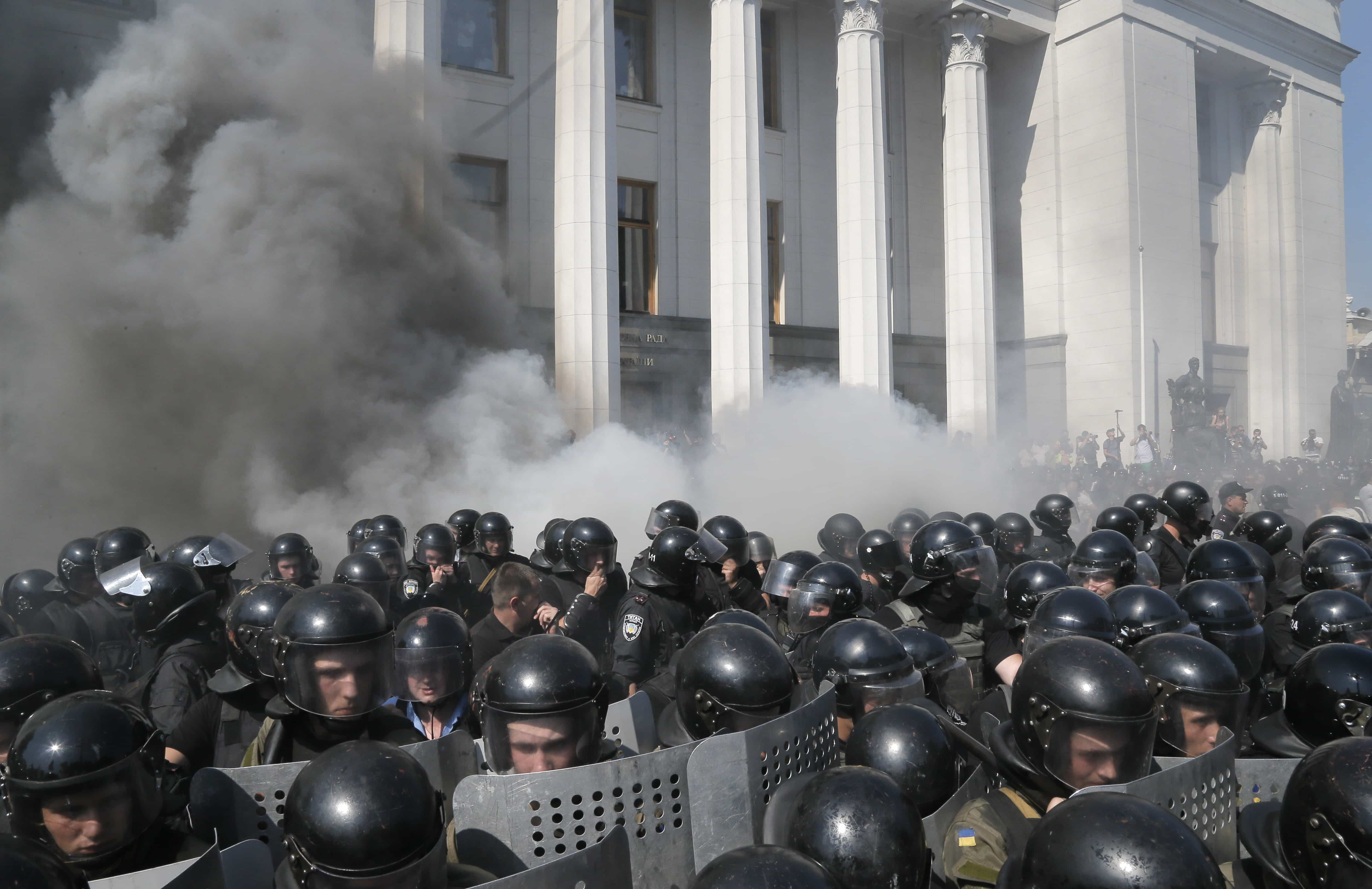 Smoke rises from outside the parliament building as riot police clash with protestors, in Kiev, 31 August 2015, AP Photo/Efrem Lukatsky