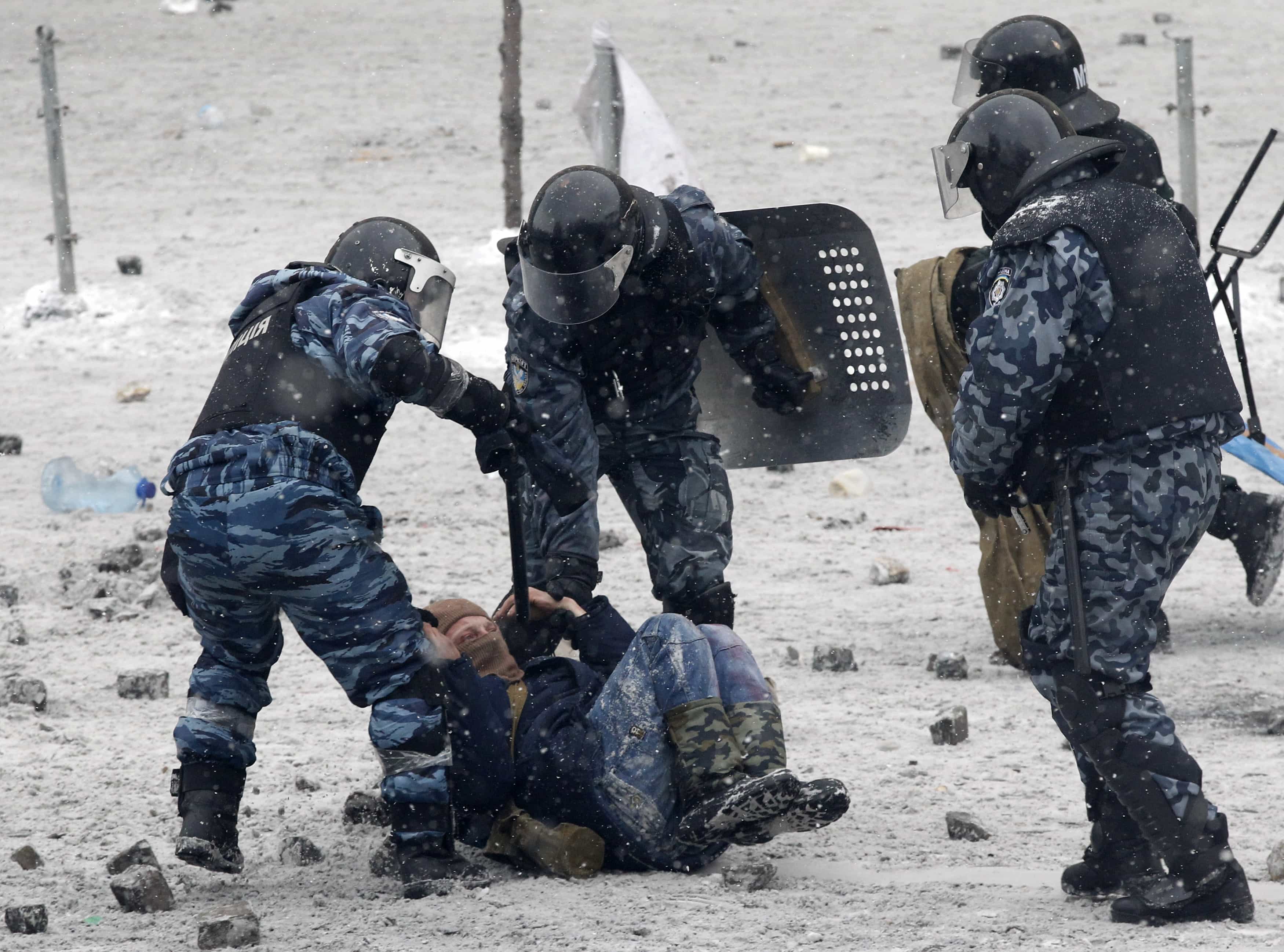 Riot police officers hold a man lying on the ground during clashes between police and pro-European protesters in Kiev, 22 January 2014., REUTERS/Vasily Fedosenko