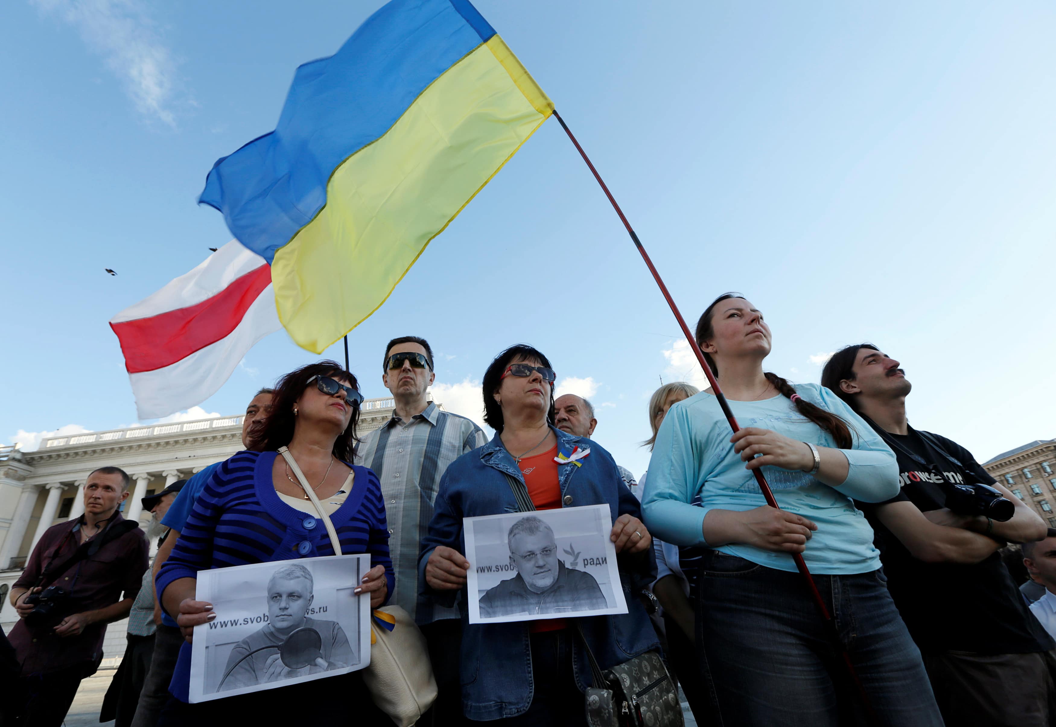 People hold national falgs of Belarus and Ukraine and portraits of journalist Pavel Sheremet who was killed by a car bomb, during a memorial ceremony in Kiev, Ukraine, 20 July 2016, REUTERS/Valentyn Ogirenko