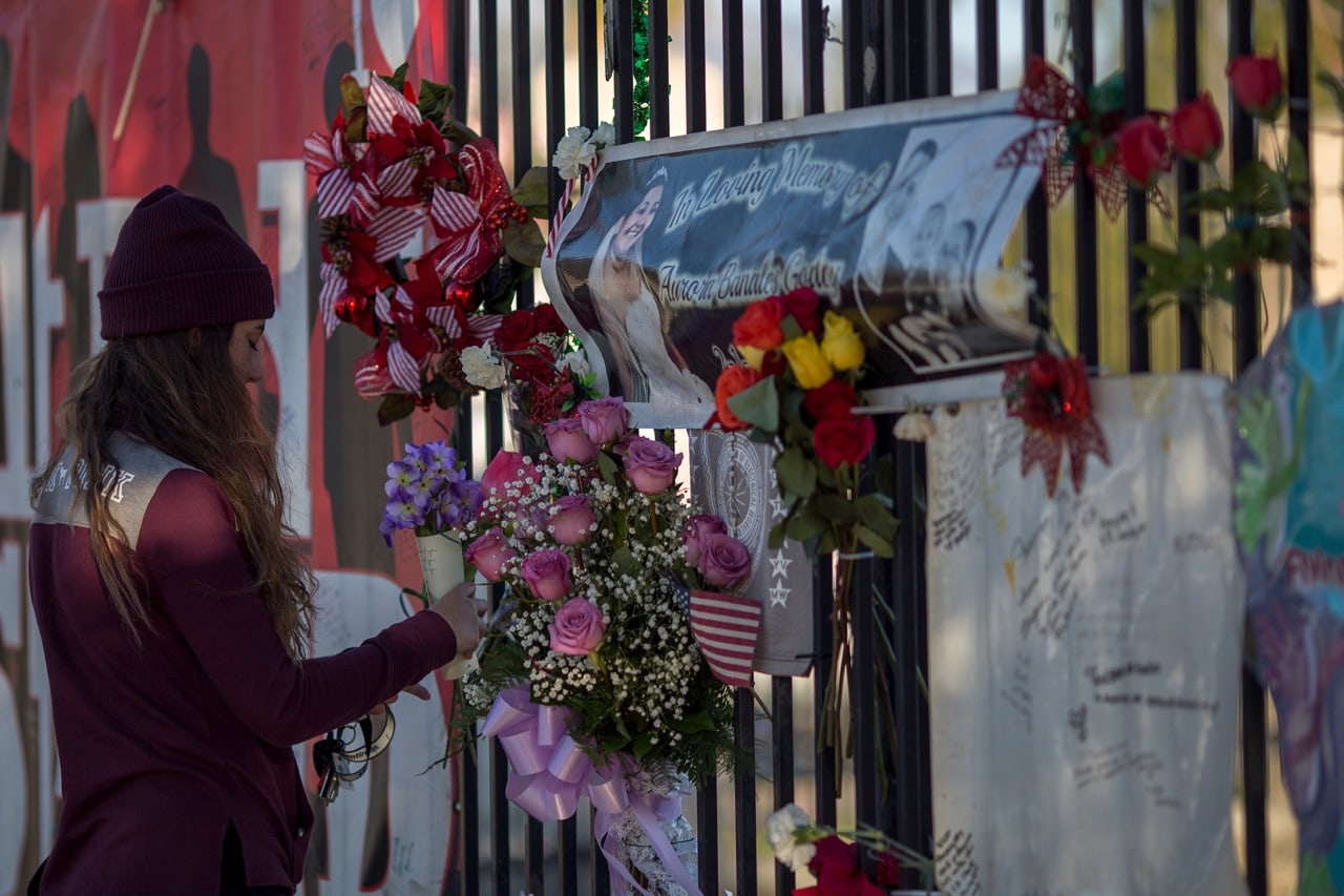 A woman brings flowers to a makeshift memorial on the one-year anniversary of the San Bernardino massacre in San Bernardino, California, 2 December 2016, David McNew/Getty Images