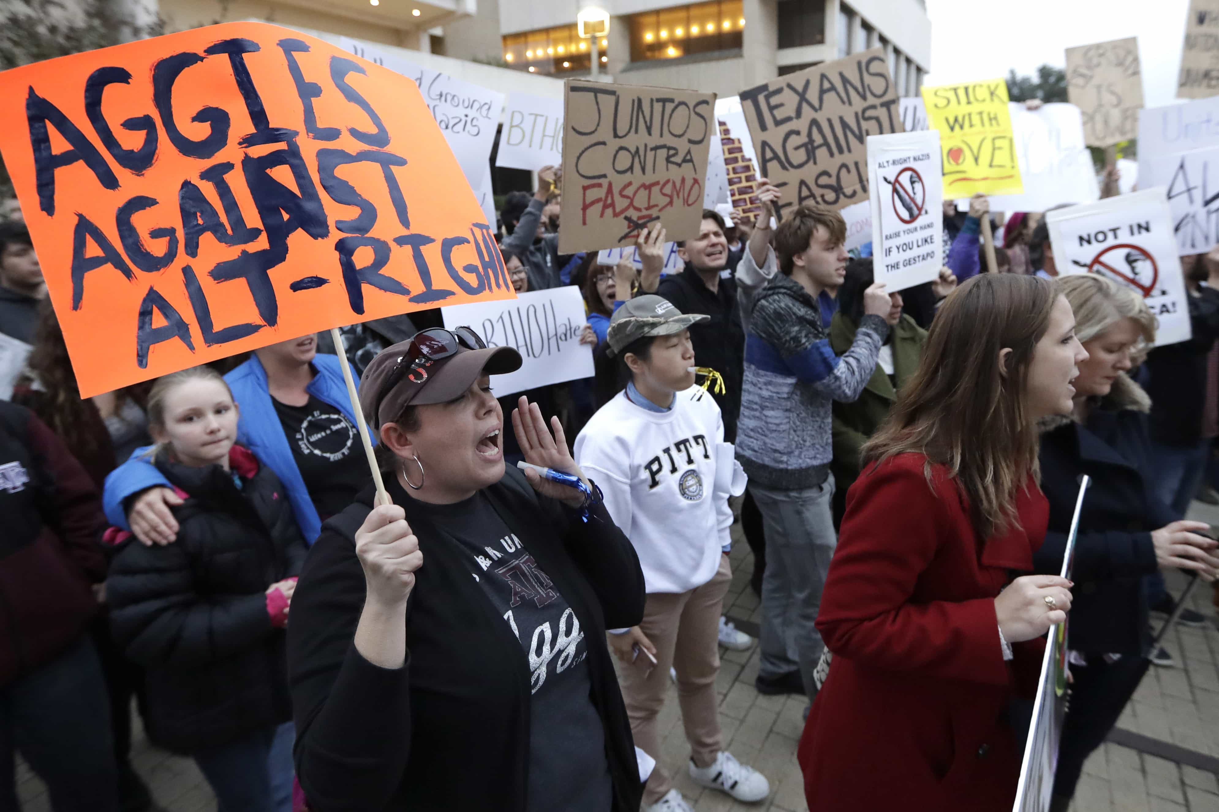 Demonstrators hold signs as they chant outside the venue where Richard Spencer, who leads a movement that mixes racism, white nationalism and populism, was scheduled to speak at Texas A&M University, 6 December 2016, AP Photo/David J. Phillip