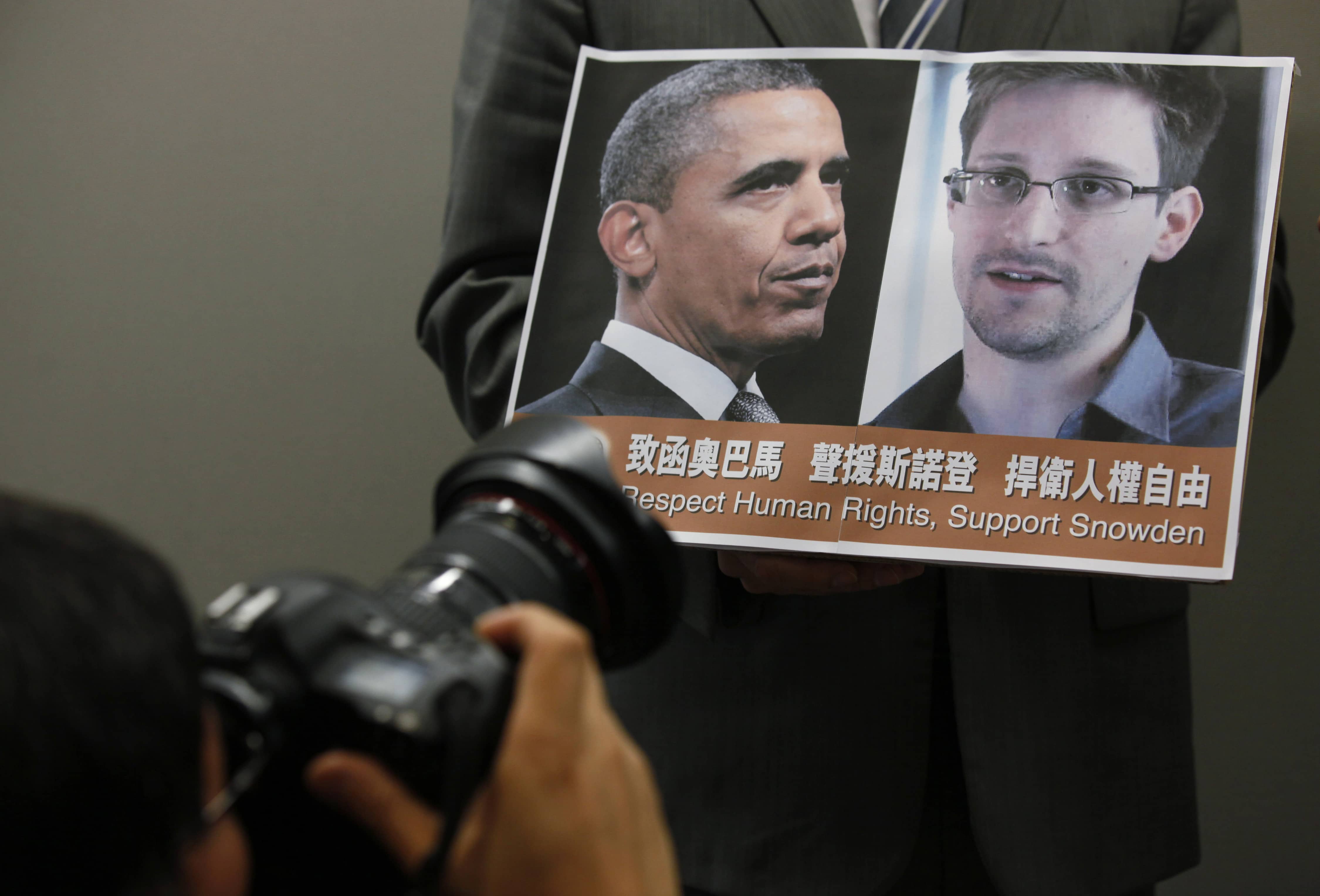 Images of President Barack Obama and Edward Snowden are held by a pro-democractic legislator during a news conference in Hong Kong in 2013, AP Photo/Kin Cheung, File