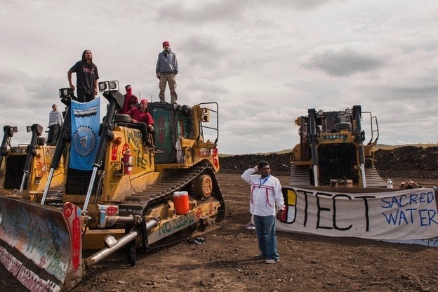 Protesters stand on heavy machinery after halting work on the Dakota Access oil pipeline near the Standing Rock Sioux reservation near Cannon Ball, North Dakota, 6 September 2016, REUTERS/Andrew Cullen