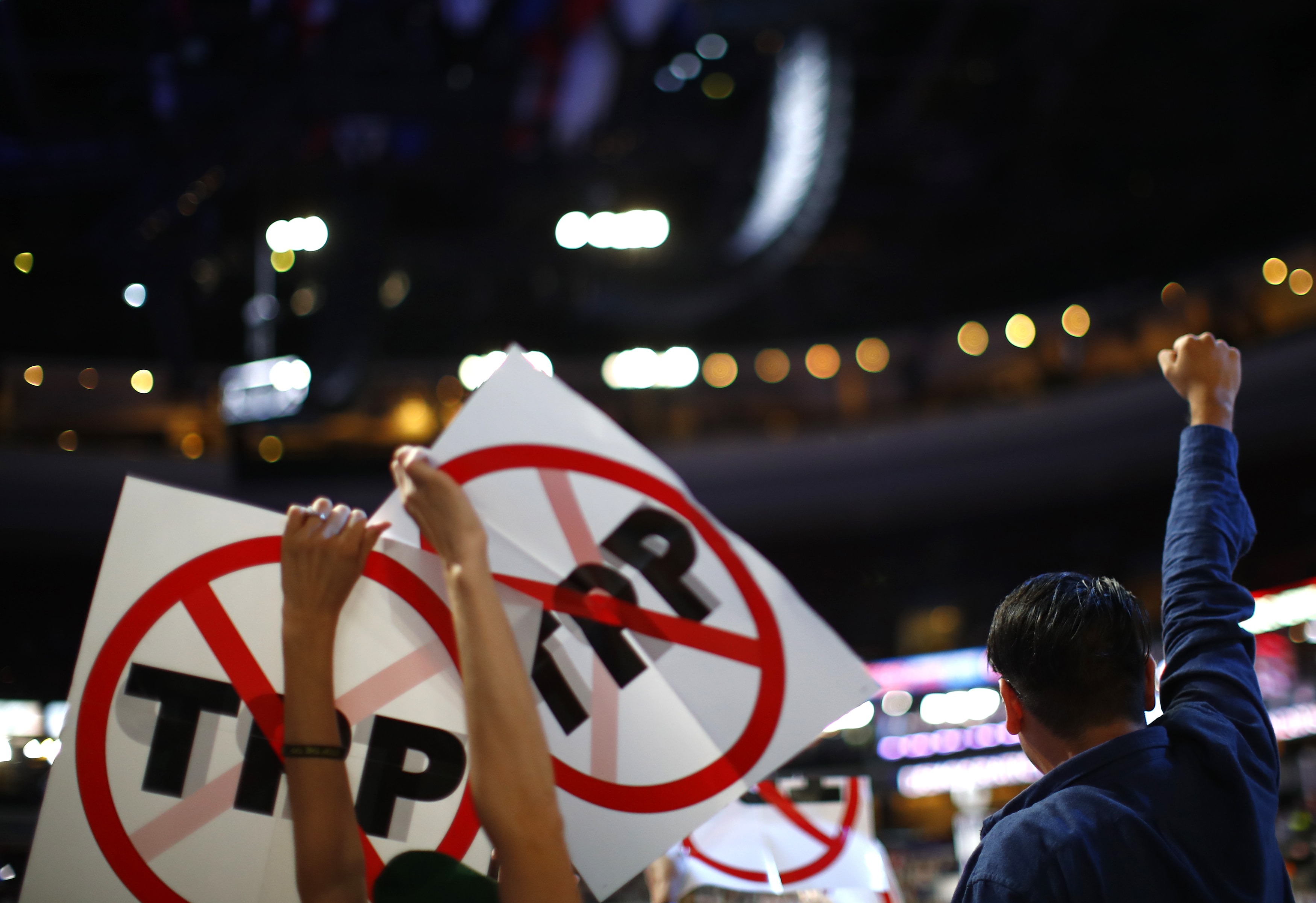 Delegates protesting against the Trans Pacific Partnership trade agreement hold up signs during the first sesssion at the Democratic National Convention in Philadelphia, Pennsylvania, July 2016, REUTERS/Carlos Barria