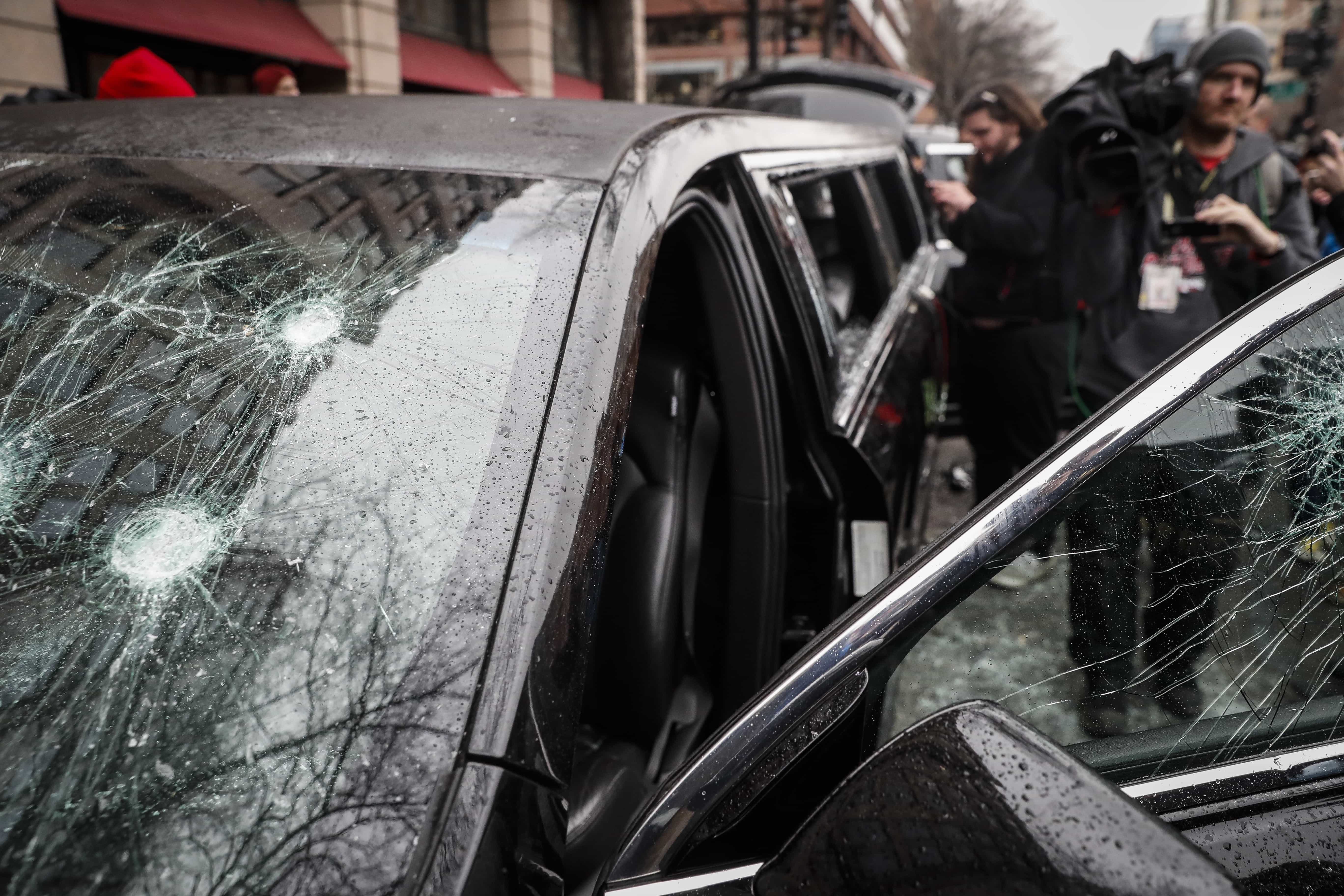 Members of the news media inspect the broken glass of a limousine during a demonstration after the inauguration of President Donald Trump, AP Photo/John Minchillo