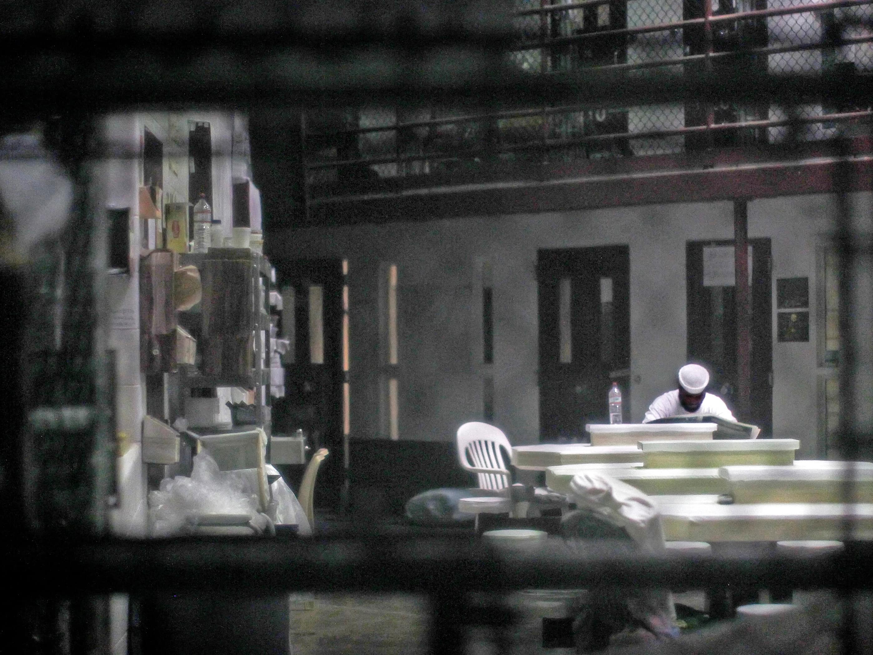 Some of American writer John Grisham's books are not allowed in Guantanamo Bay; in this March 2013 photo an unidentified prisoner reads a newspaper in a communal cellblock on the U.S. Naval Base, REUTERS/Bob Strong