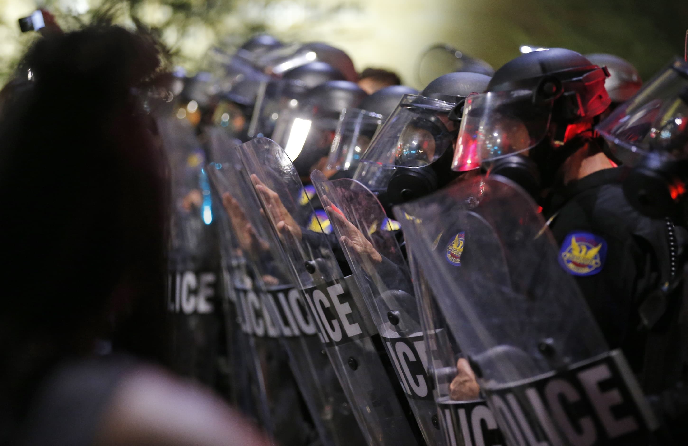 Police in riot gear block a street as hundreds of marchers take to the streets to protest against the recent fatal shootings of black men by police July 8, 2016, AP Photo/Ross D. Franklin