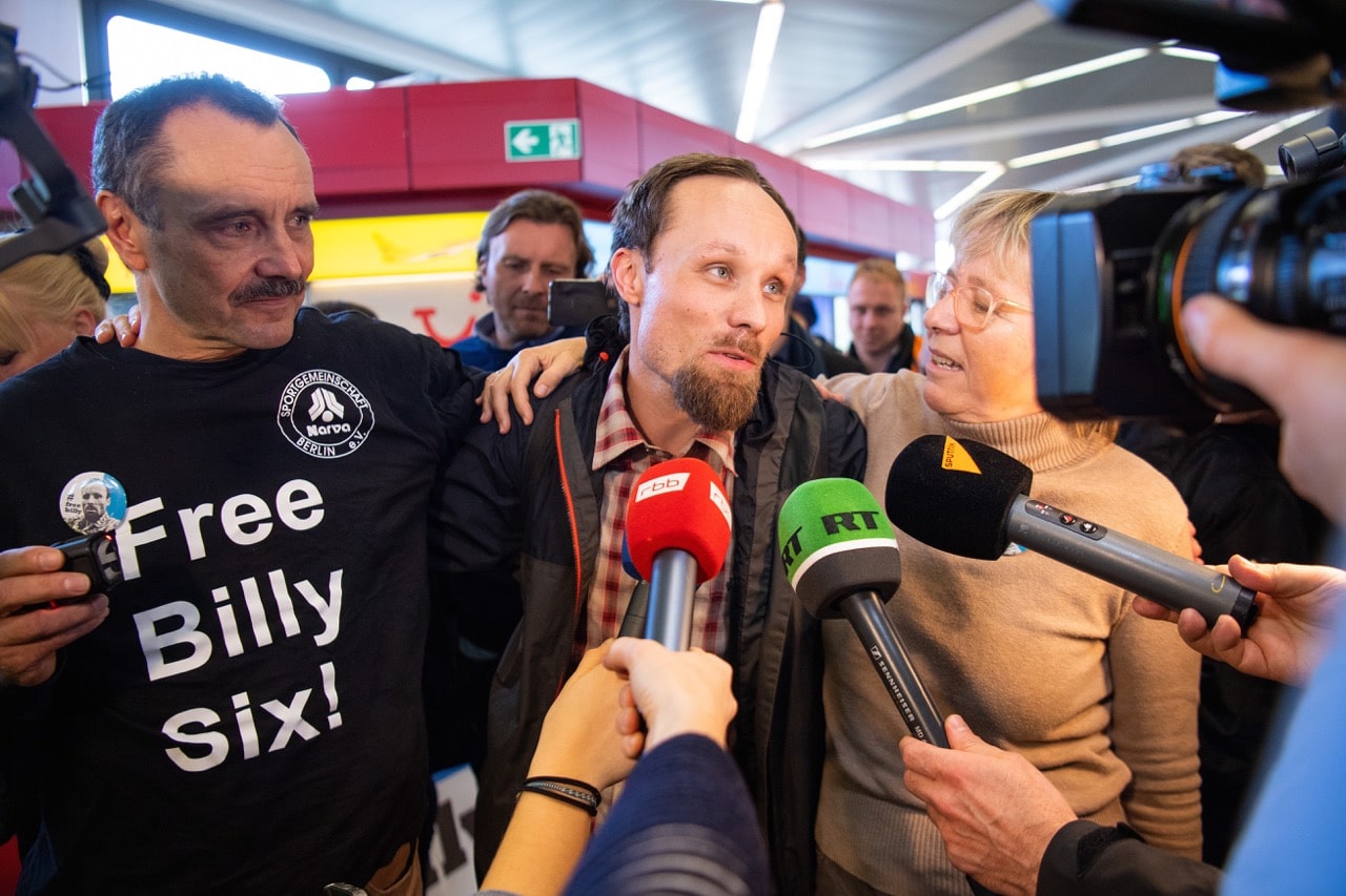 The German journalist Billy Six (M) talks to journalists after arriving at Tegel Airport, 18 March 2019; next to him are his father Edward (l) and his mother Ute, Monika Skolimowska/picture alliance via Getty Images