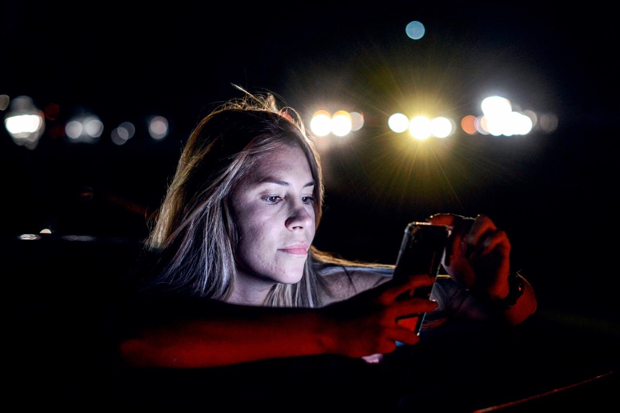 A woman uses her mobile phone at a spot where she can get service during a partial power outage in Caracas, Venezuela, 9 March 2019, MATIAS DELACROIX/AFP/Getty Images