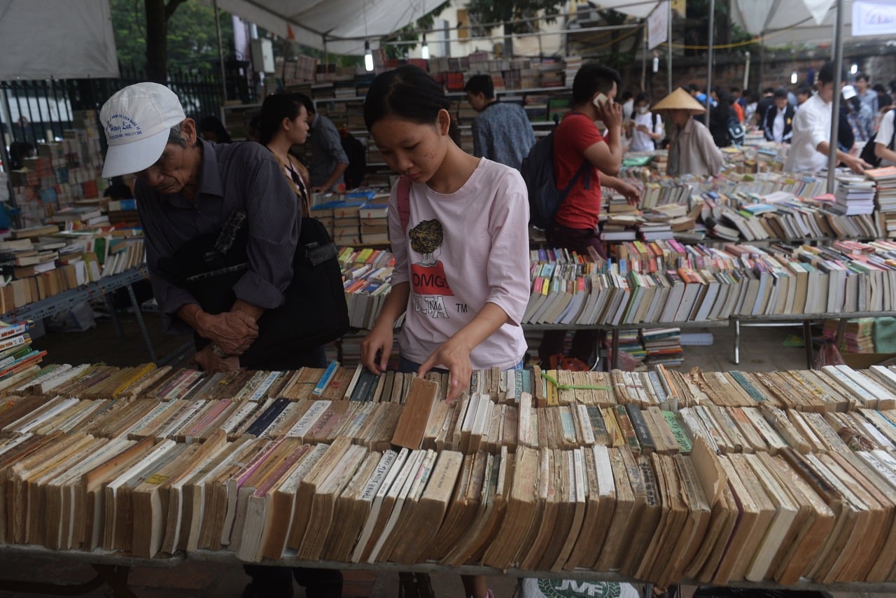 A young woman browses used books on display at a book fair in Hanoi, Vietnam, 26 October 2017, HOANG DINH NAM/AFP/Getty Images