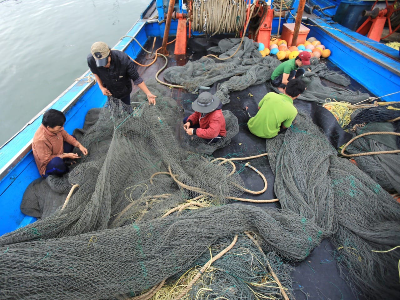 Vietnamese fishermen fix nets on their boat, 27 March 2016, AP Photo/Hau Dinh