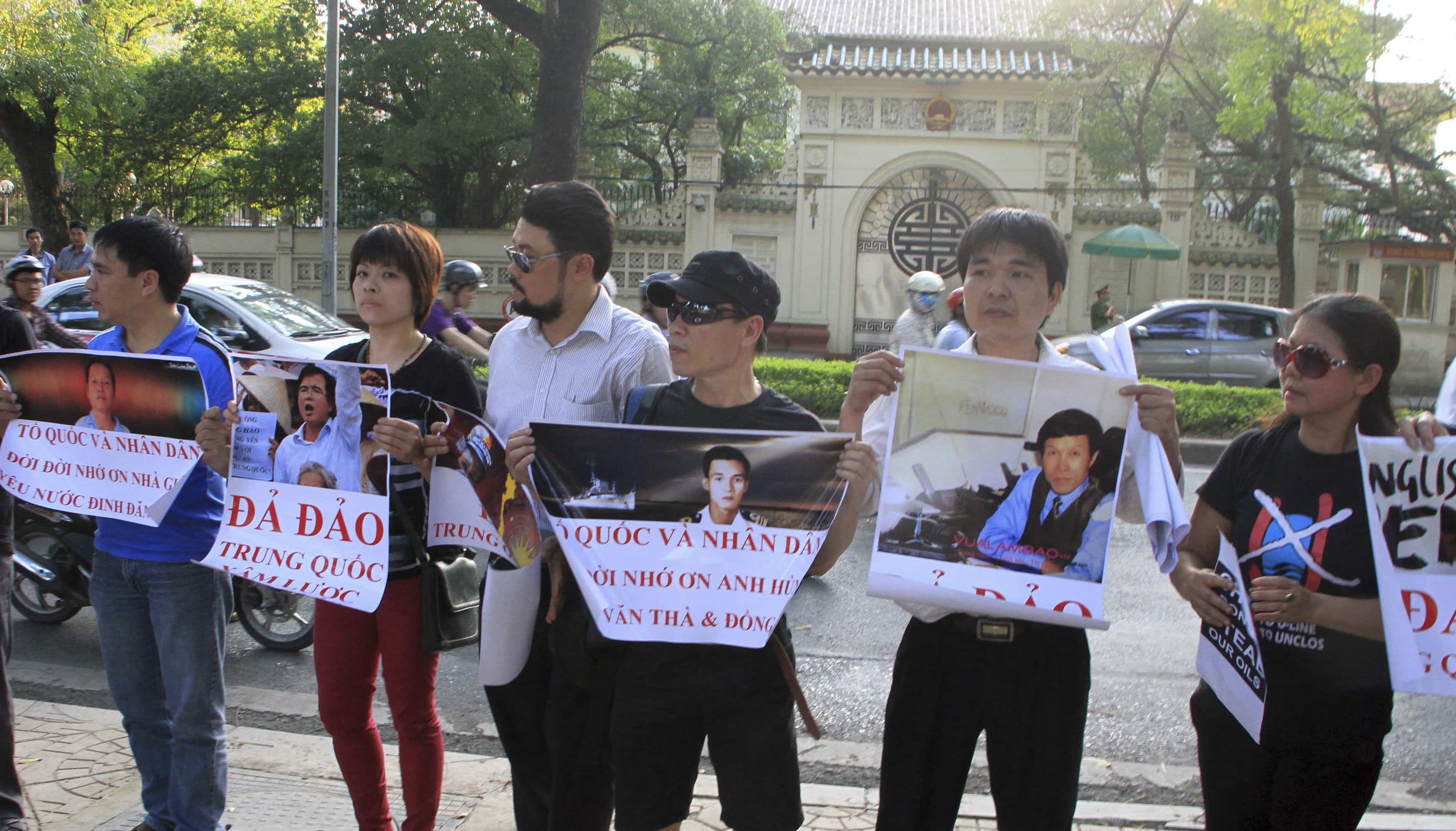 rotesters hold placards with images of activists (L-R) Dinh Dang Dinh, Le Quoc Quan, naval officer Nguy Van Tha and blogger Nguyen Huu Vinh, as they gather in front of the Chinese embassy in Hanoi, 9 May 2014, REUTERS/ Nguyen Huu Vinh