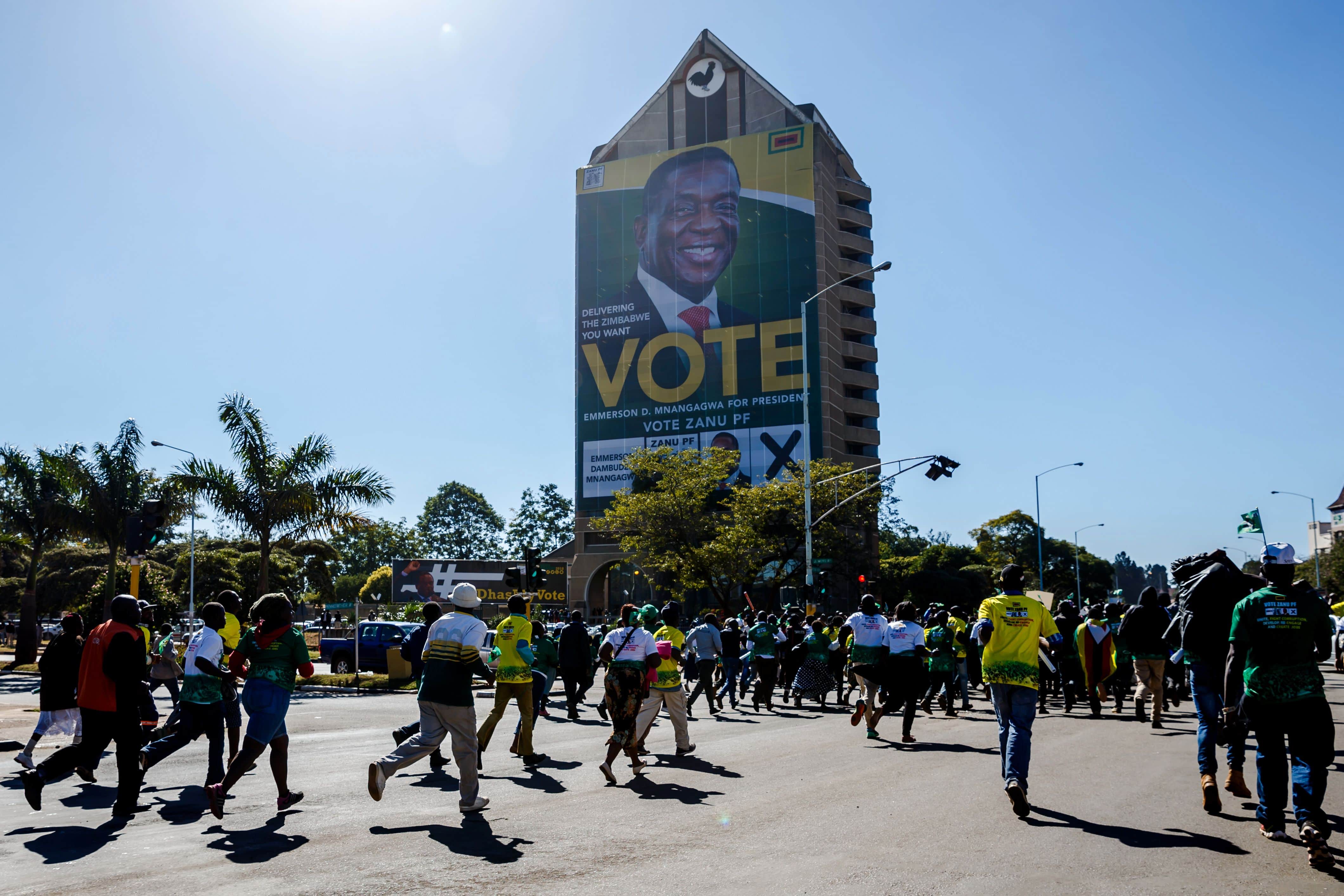 ZANU-PF Youth League members cheer as they march ahead of the July 30 general elections, Harare, Zimbabwe, 2018, JEKESAI NJIKIZANA/AFP/Getty Images