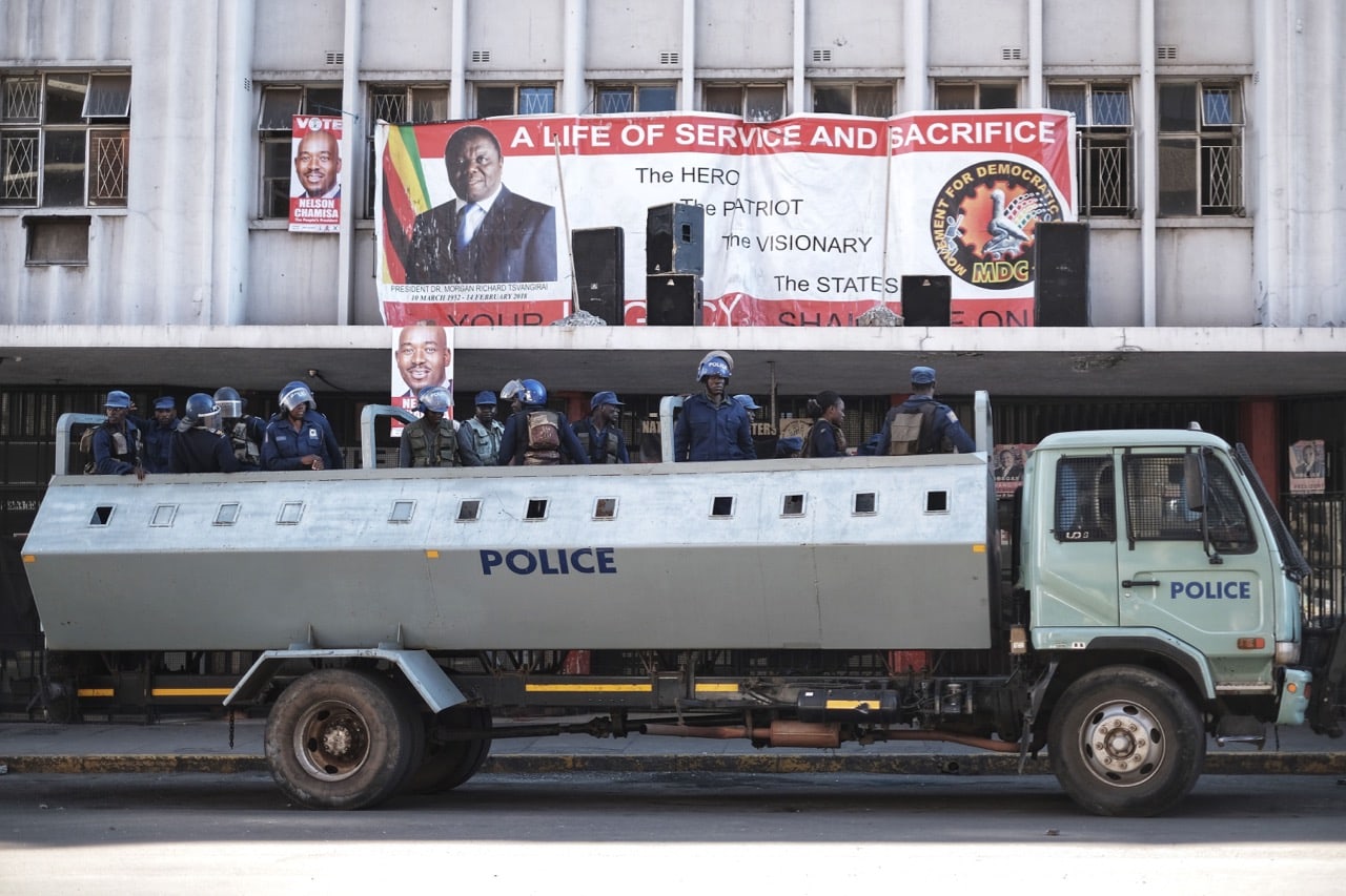 Zimbabwean riot police officers stand guard in front of the headquarters of the opposition party Movement for Democratic Change (MDC) in Harare, 2 August 2018, MARCO LONGARI/AFP/Getty Images