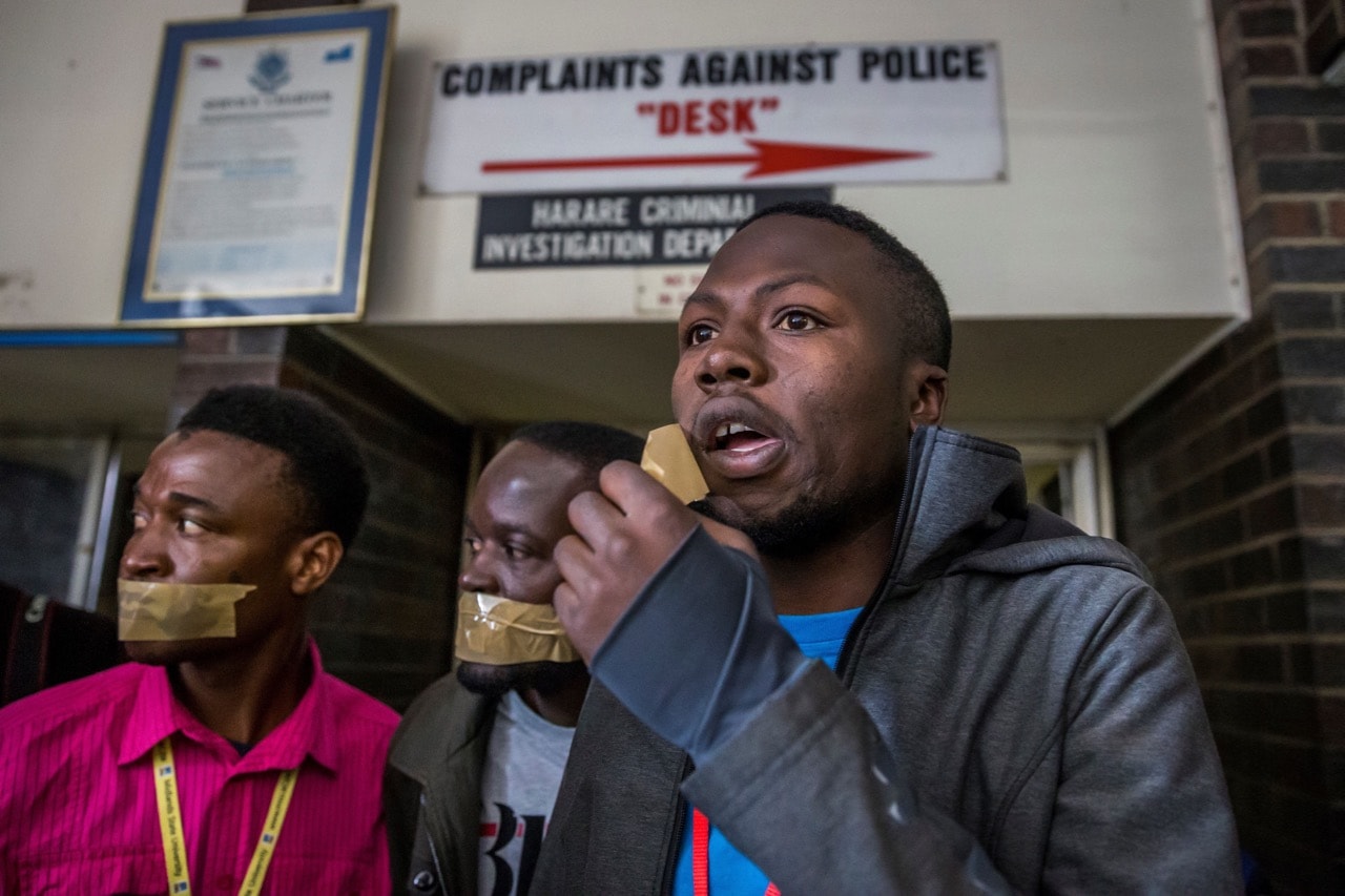 Zimbabwean journalists with tape over their mouths protest against police methods at the Harare Central Police Station, Harare, 28 July 2017, JEKESAI NJIKIZANA/AFP/Getty Images