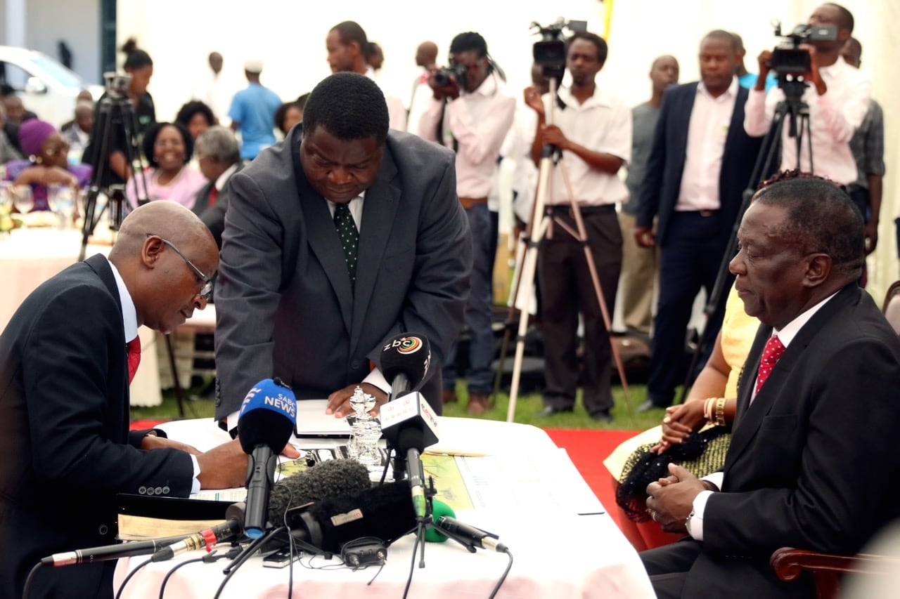 Zimbabwean Minister of Justice Ziyambi Ziyambi signs the oath of office as President Emmerson Mnangagwa looks on during the swearing in ceremony at State House in Harare, Zimbabwe, 4 December 2017, REUTERS/Philimon Bulawayo