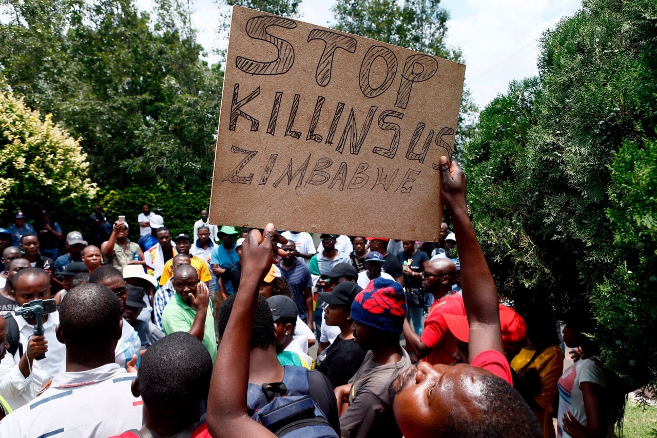 A protester holds a placard during a demonstration of Zimbabwean citizens outside the Zimbabwean Embassy in Pretoria, South Africa, 16 January 2019, PHILL MAGAKOE/AFP/Getty Images