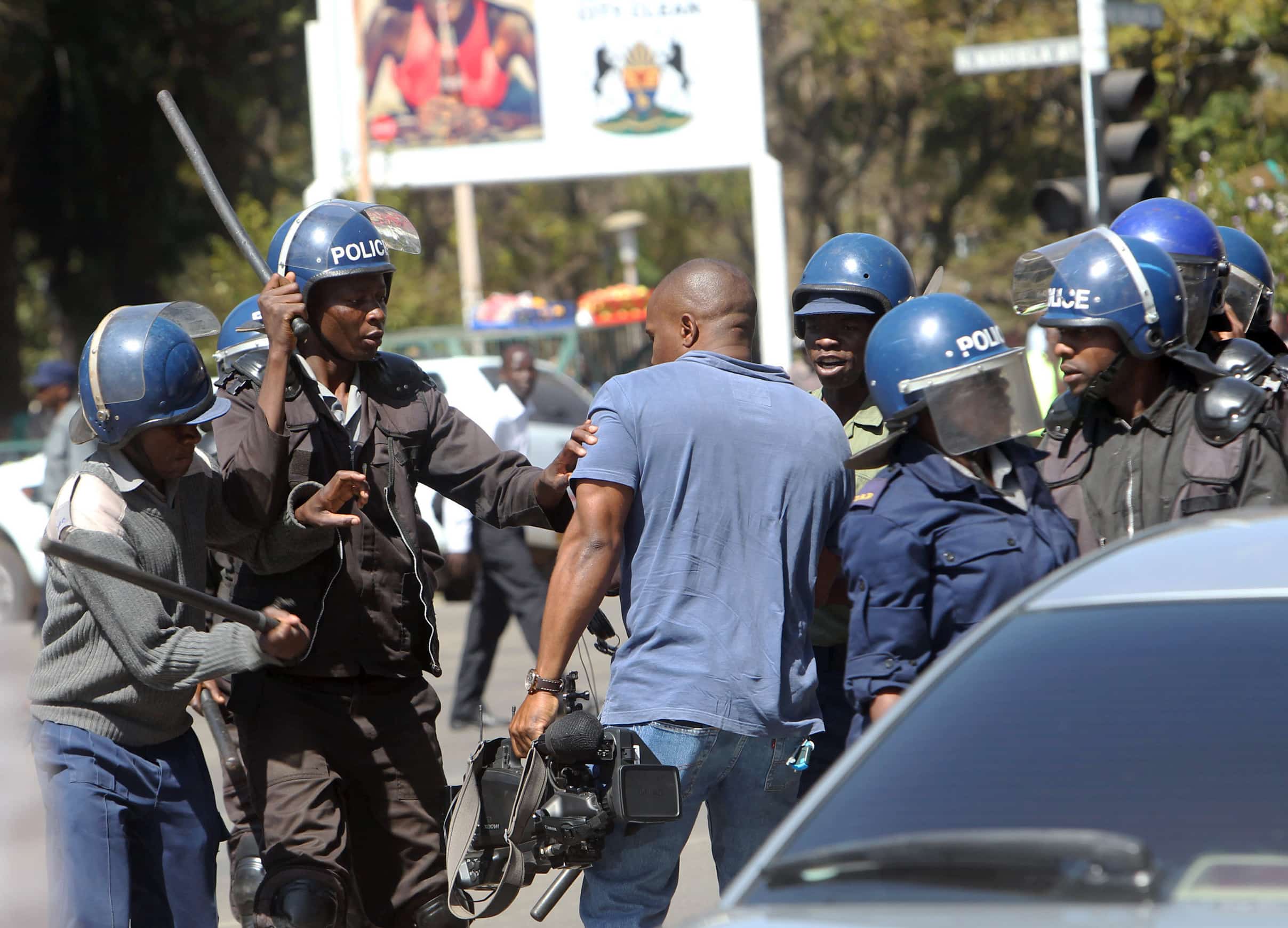 A cameraman is hit by the police during demonstrations in Harare, 3 August 2016, AP Photo/Tsvangirayi Mukwazhi