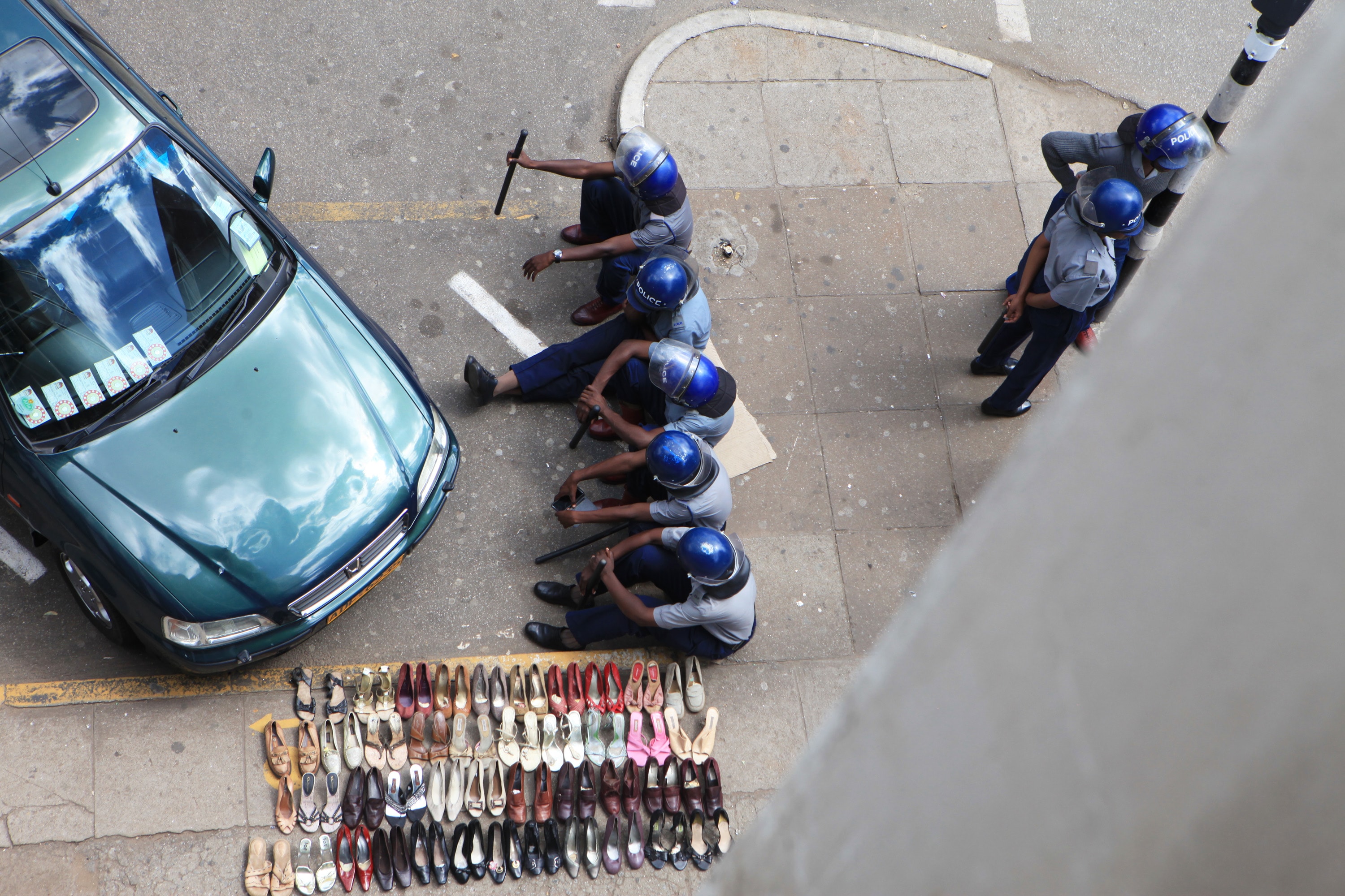 Police sit outside the sealed headquarters of Zimbabwe's main opposition party in Harare, as tensions rise over the disappearance of Itai Dzamara, 12 March 2015, AP Photo/Tsvangirayi Mukwazhi