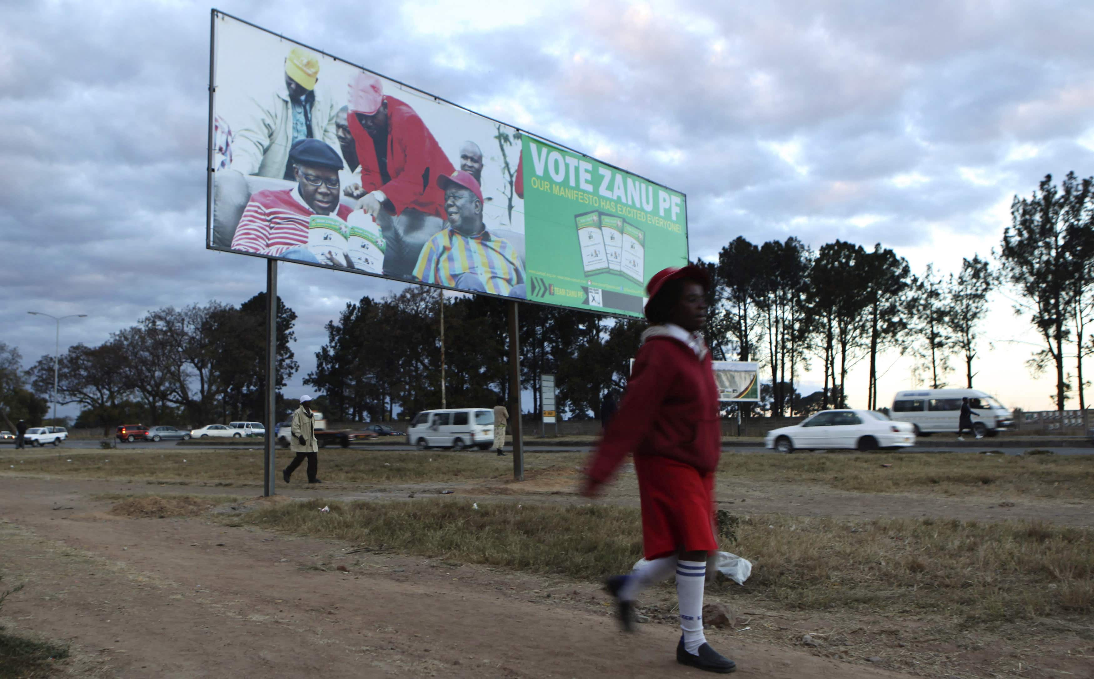 A child walks past an election billboard for Zimbabwe's President Robert Mugabe's ZANU-PF party in Harare, 2 August 2013., REUTERS/Philimon Bulawayo