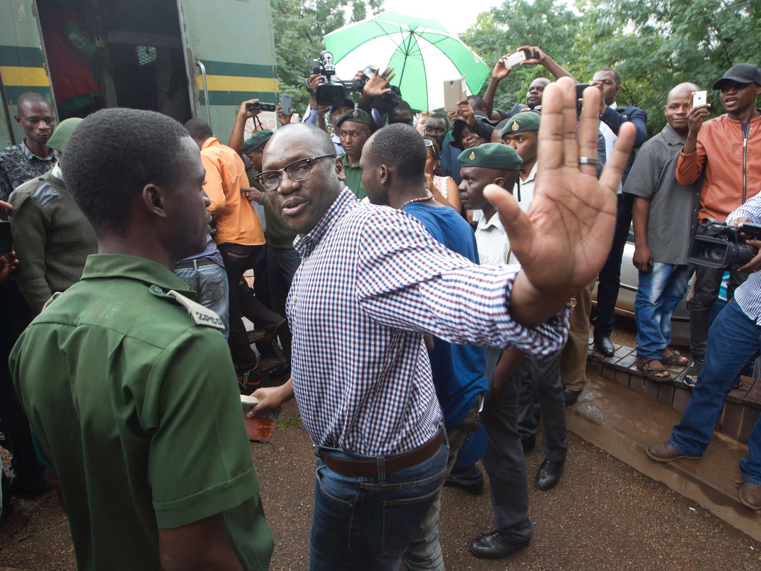 Evan Mawarire waves goodbye as he is taken into a prison truck at the Magistrates Court in Harare, 3 February 2017, AP Photo/Tsvangirayi Mukwazhi