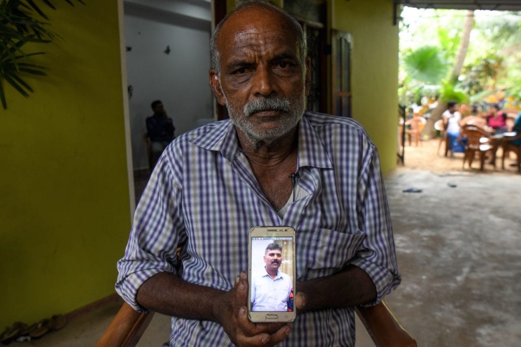 Velusami Raju, father of the Zion Church suicide blast victim Ramesh Raju, shows a photo of his son on a mobile phone at his house, in Kattankudy, Sri Lanka, 26 April 2019, LAKRUWAN WANNIARACHCHI/AFP/Getty Images