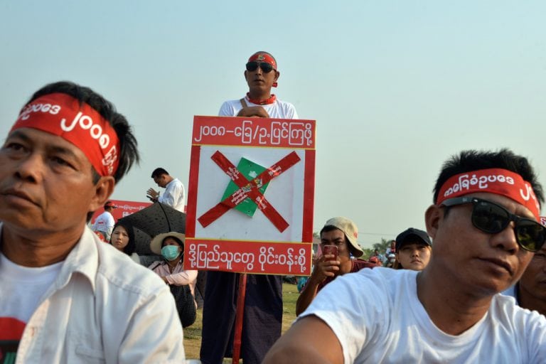 A man (C) stands with a placard during a rally calling for reforms to the 2008 constitution in Naypyidaw, Burma, 31 March 2019, THET AUNG/AFP/Getty Images