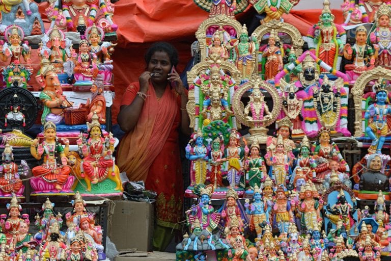 A shopkeeper speaks on her mobile phone during a festival, in Chennai, Madras, India, 10 October 2018, ARUN SANKAR/AFP/Getty Images