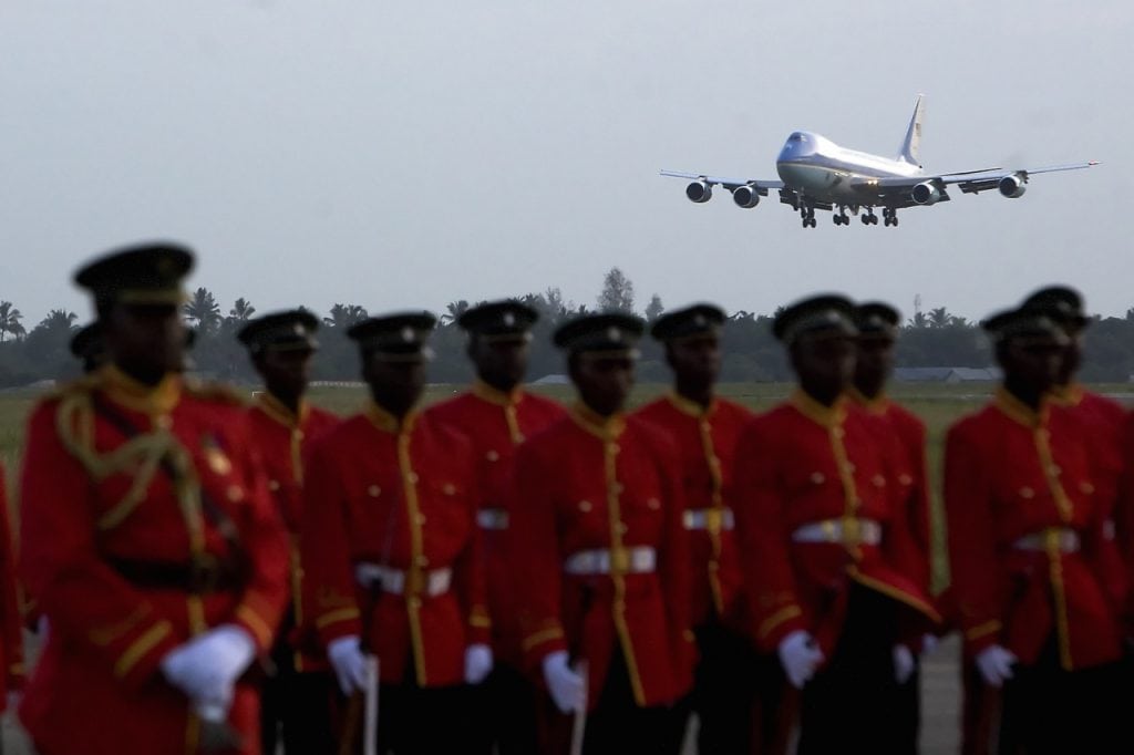 Tanzanian troops stand at rest as a plane comes in a for a landing at Julius Nyerer International Airport in Dar es Salaam, 16 February 2008, JIM WATSON/AFP/Getty Images