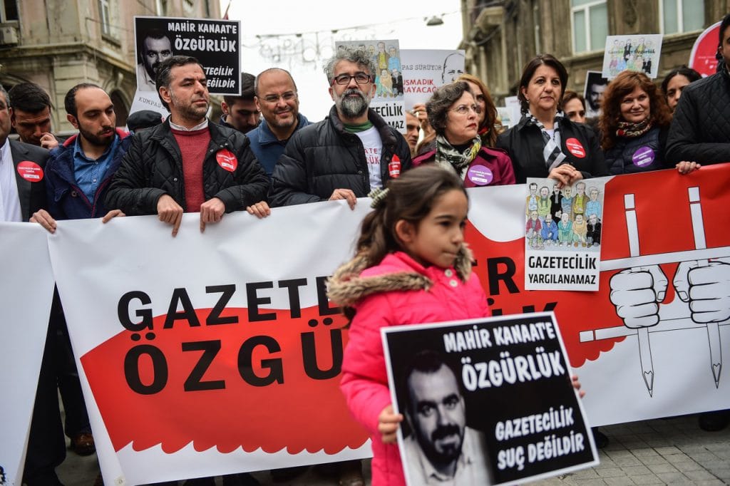 Parliament members from the main opposition party, the Pro Kurdish People's democracy Party and RSF representative Erol Onderoglu (C) hold banners reading 'Freedom for jailed journalists - we will not be silenced', in Istanbul, Turkey, 9 April 2017, YASIN AKGUL/AFP/Getty Images