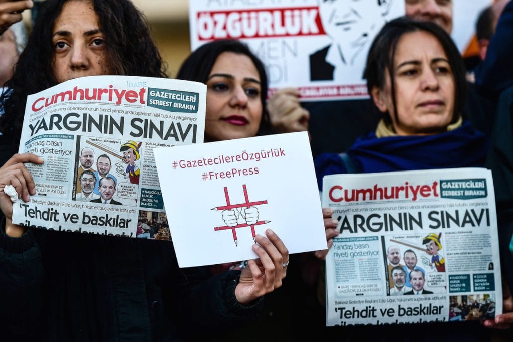 Protesters hold copies of the "Cumhuriyet" newspaper and placards during a demonstration in front of a courthouse in Istanbul, Turkey, 31 October 2017, YASIN AKGUL/AFP/Getty Images