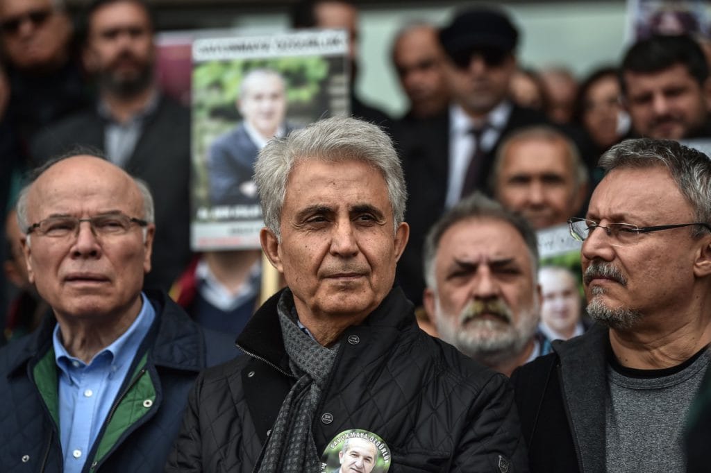 "Cumhuriyet" daily's cartoonist Musa Kart (C) stands with colleagues at a demonstration calling for the freedom of all jailed journalists at a courthouse in Istanbul, Turkey, 15 March 2018, OZAN KOSE/AFP/Getty Images