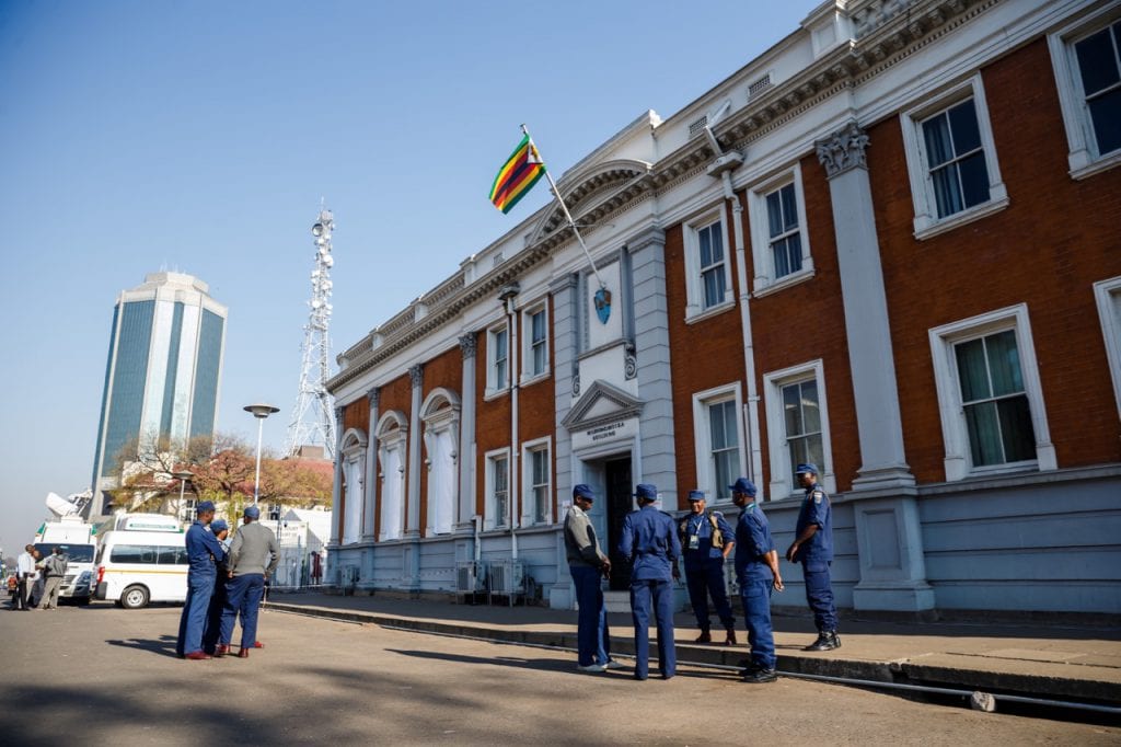 Policemen stand guard outside a courthouse, in Harare, Zimbabwe, 22 August 2018, JEKESAI NJIKIZANA/AFP/Getty Images