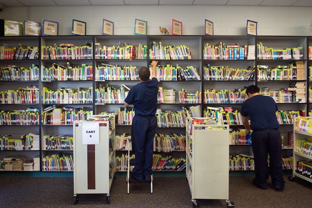 Students organise books at the library at the Fischer School in Orange County Juvenile Hall in Orange, CA, 8 August 2013, Paul Bersebach/Digital First Media/Orange County Register via Getty Images