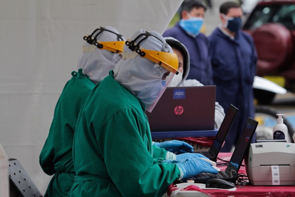 Unos trabajadores de salud entran los datos personales de los pacientes durante unas pruebas para el Covid-19, en Quito, Ecuador, el 19 de agosto de 2020, Franklin Jacome/Agencia Press South/Getty Images