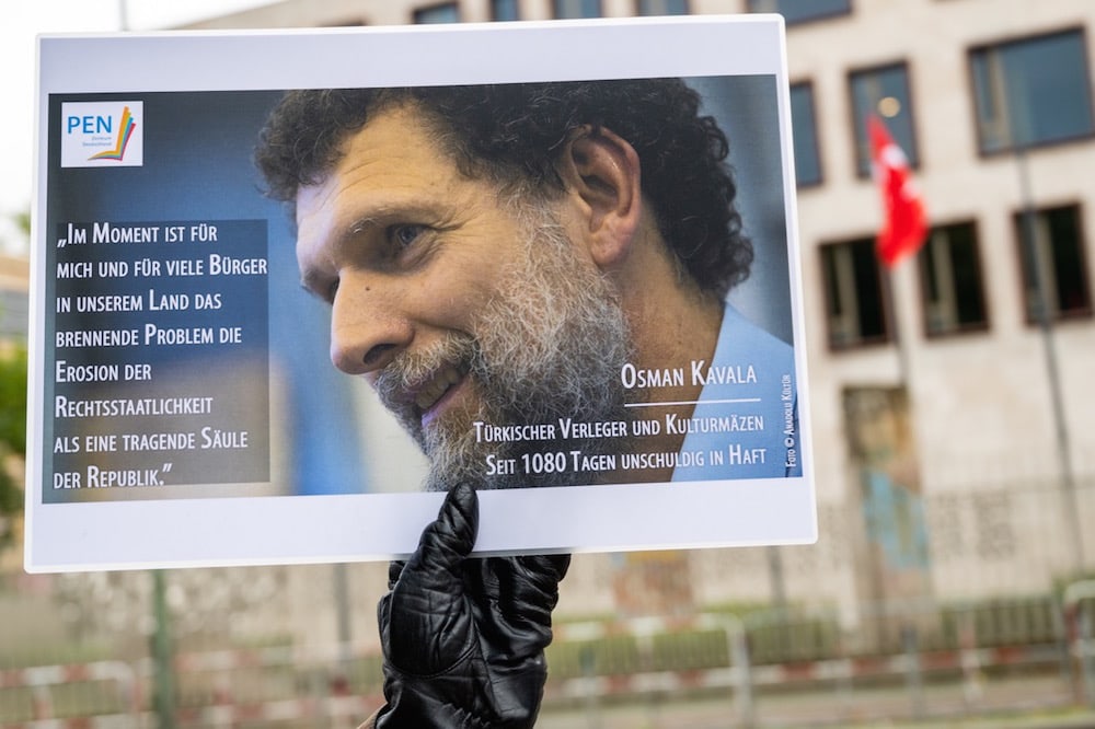 Berlin, Allemagne, le 15 octobre 2020. Un manifestant tient une photo d’Osman Kavala, leader emprisonné de la société civile turque, lors d'une veillée devant l'ambassade de Turquie. Christophe Gateau / photo alliance via Getty Images