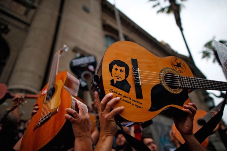 Demonstrators hold up their guitars after performing the song "El derecho de vivir en paz' ("The right to live in peace") by the late musician Victor Jara, during a protest in Santiago, Chile, 25 October 2019, PABLO VERA/AFP via Getty Images