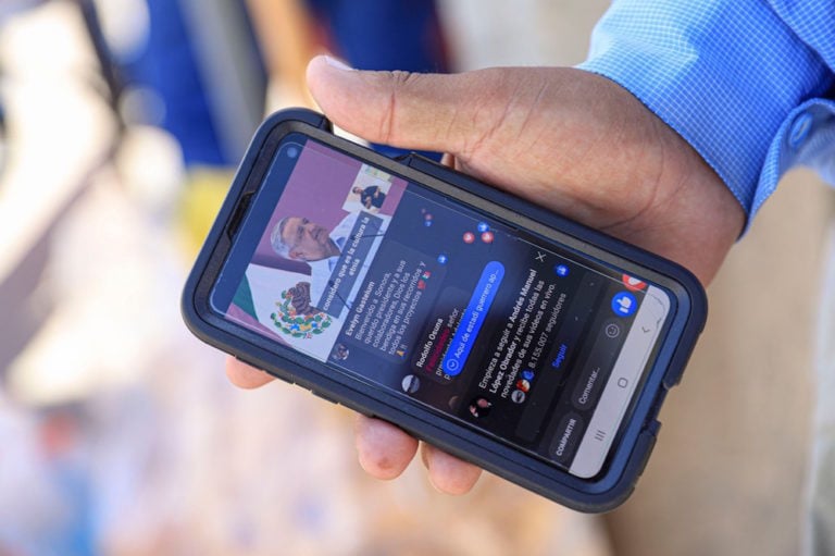 Un hombre mira a su teléfono y a una transmisión en vivo del Presidente AMLO, en Hermosillo, México, el 4 de octubre de 2020, Luis Gutierrez/Norte Photo/Getty Images