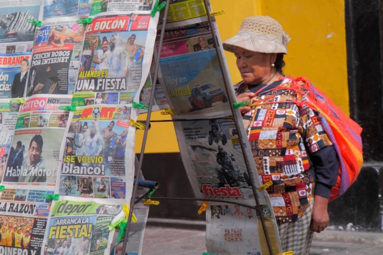 Una mujer quechua mira a las portadas de unos diarios en un kiosco, Lima, Perú, el 14 de enero de 2012, Jeffrey Greenberg/Universal Images Group via Getty Images