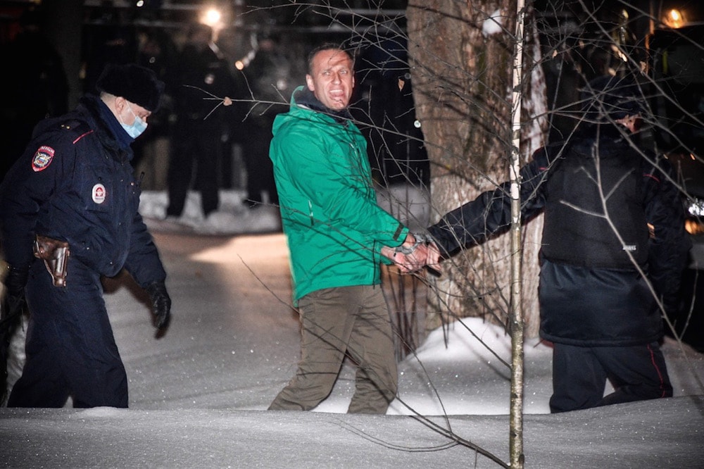 Opposition leader Alexei Navalny is escorted out of a police station in Khimki, outside Moscow, 18 January 2021, following the court ruling that ordered him jailed for 30 days. ALEXANDER NEMENOV/AFP via Getty Images