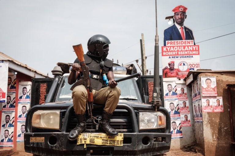A heavily armed police officer sits on a car positioned outside the headquarters of Bobi Wine's National Unity Platform (NUP), in Kampala, Uganda, 18 January 2021, YASUYOSHI CHIBA/AFP via Getty Images