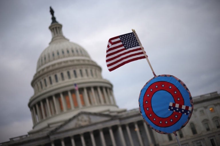 Supporters of former U.S. President Donald Trump fly a flag with a symbol from the group QAnon as they gather outside the U.S. Capitol on the day of the riot, Washington, DC., 6 January 2021, Win McNamee/Getty Images